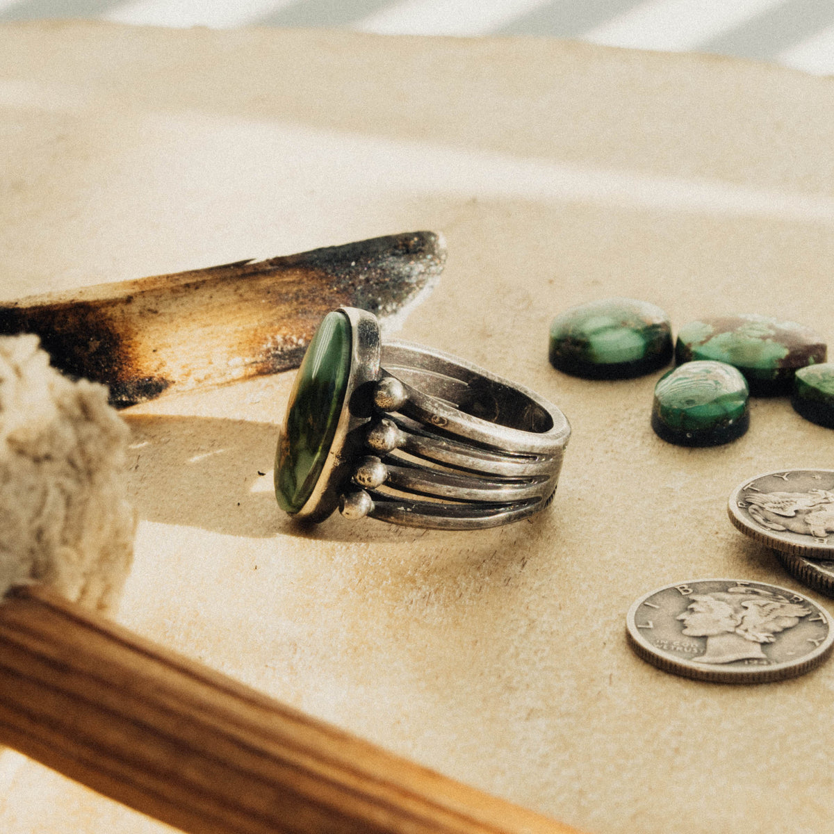 A hand-wrought sterling silver ring set with an oval Sonoran Gold turquoise stone, its green face threaded with golden-brown and rust matrix, set in a smooth straight bezel — view 2