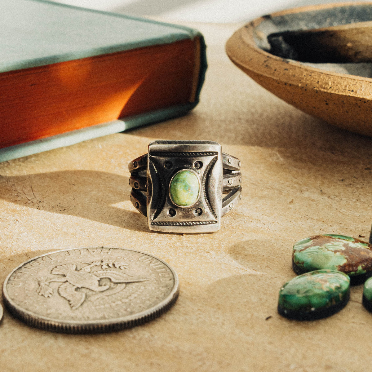 A hand-wrought sterling silver shield ring set with an oval Sonoran Gold turquoise stone, its soft green face touched with golden matrix, set in a smooth straight bezel
