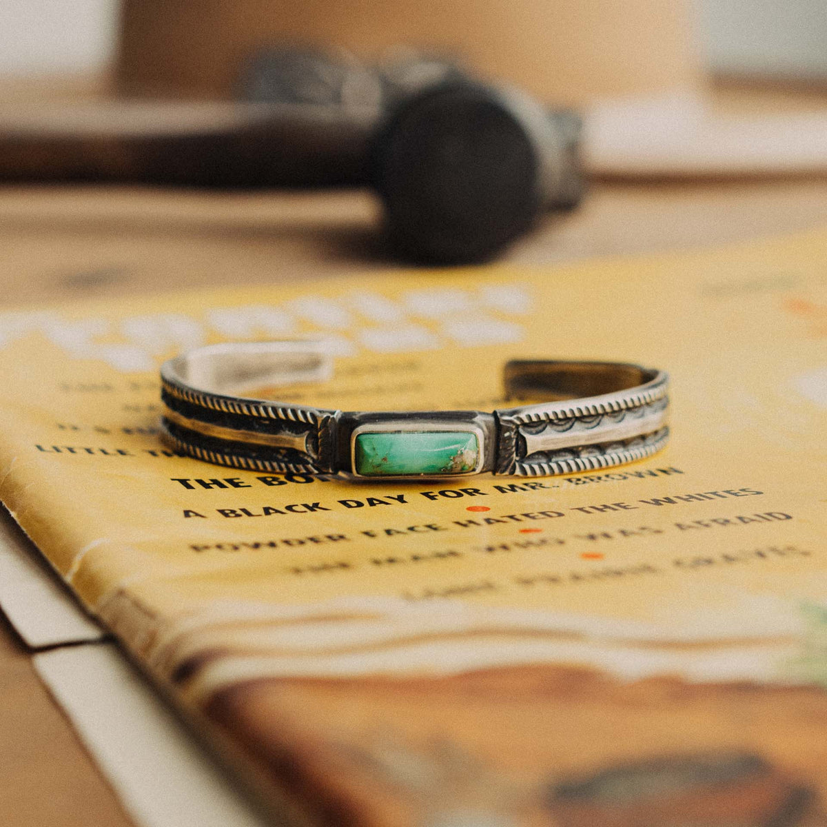 A hand-wrought sterling silver stacking cuff set with a rectangular Royston turquoise stone, its vivid true-green face threaded with warm rust-brown matrix, placed in a smooth straight bezel — view 2