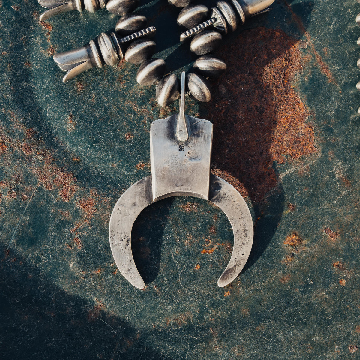 A hand-wrought sterling silver squash blossom necklace strung with substantial beads — view 6