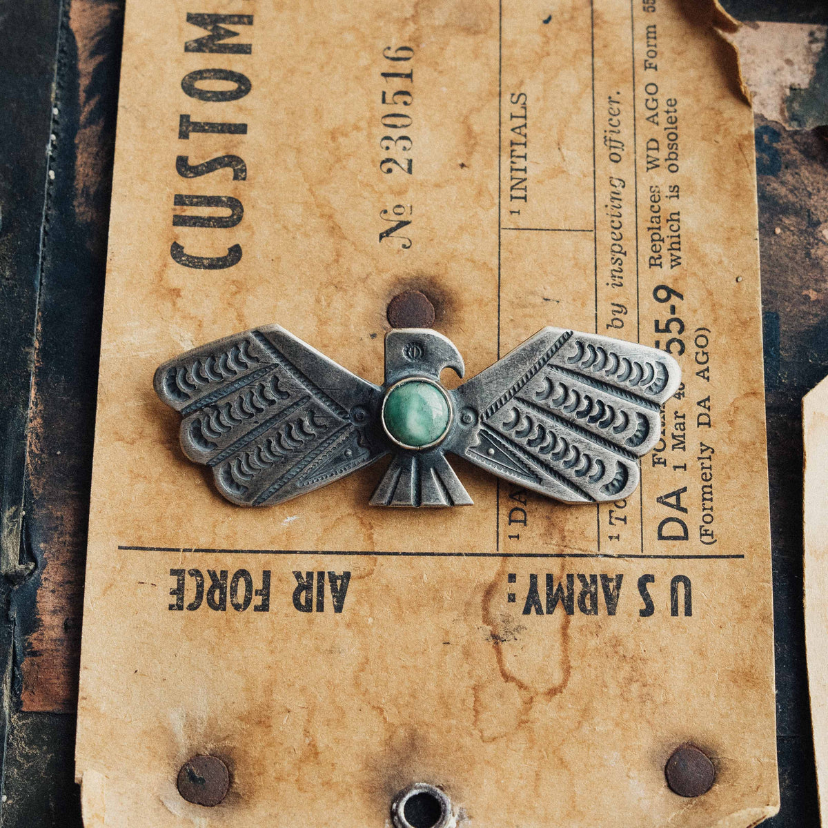 A handwrought sterling silver Thunderbird with wings outstretched, centered on a round Fox turquoise stone set in a smooth straight bezel