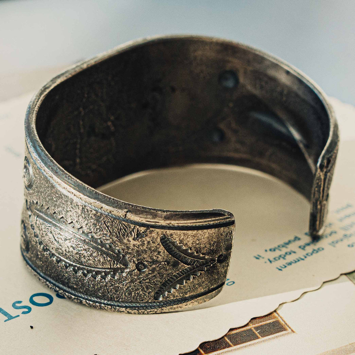 A wide tufa cast sterling silver cuff centered on a rectangular Royston turquoise stone, its soft green face threaded with rust-brown matrix, set in a smooth bezel — view 5