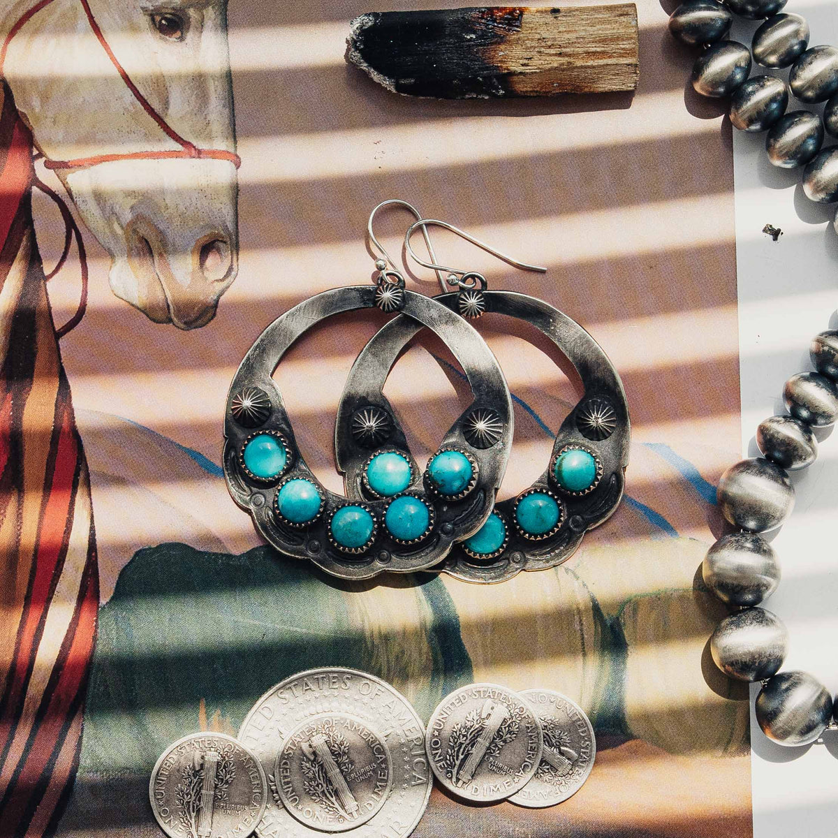 A pair of open-hoop earrings, each featuring five Carico Lake turquoise stones set in serrated bezels