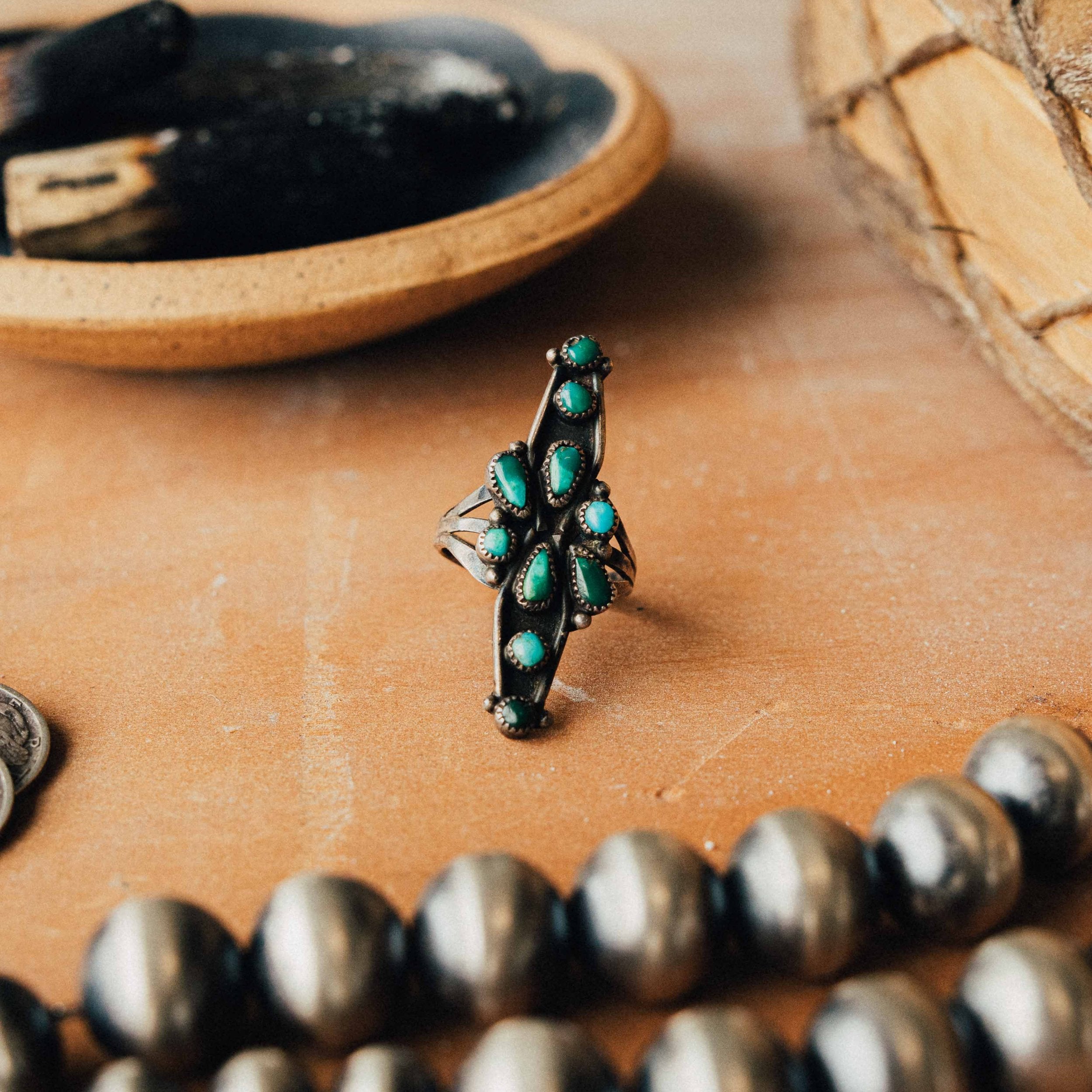A vintage Zuni snake-eye ring — mixed turquoise cluster in serrated bezels on a split shank, size 5.25