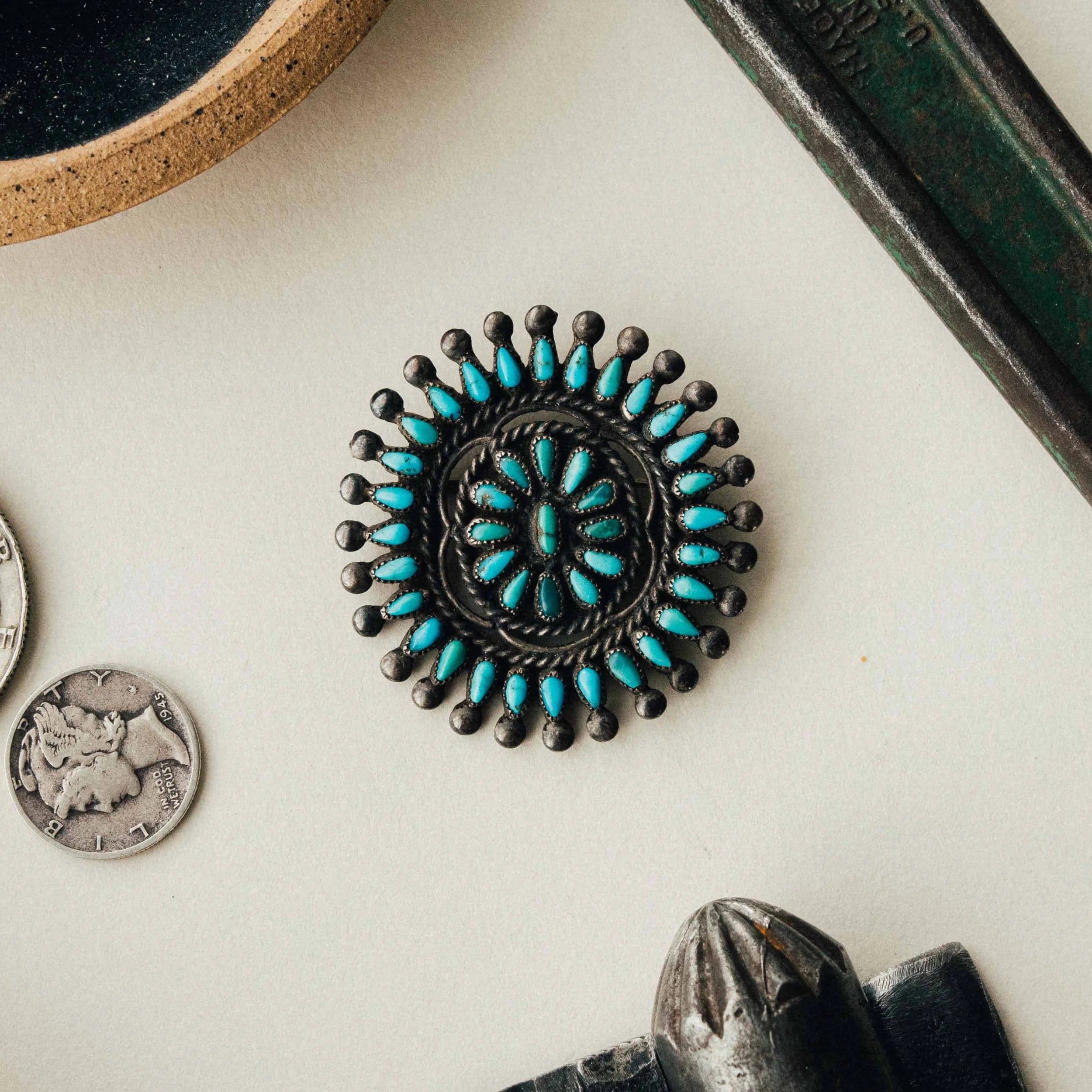 A vintage Zuni cluster pin — mixed high-grade turquoise in serrated bezels with intricate soldering and a strong natural patina