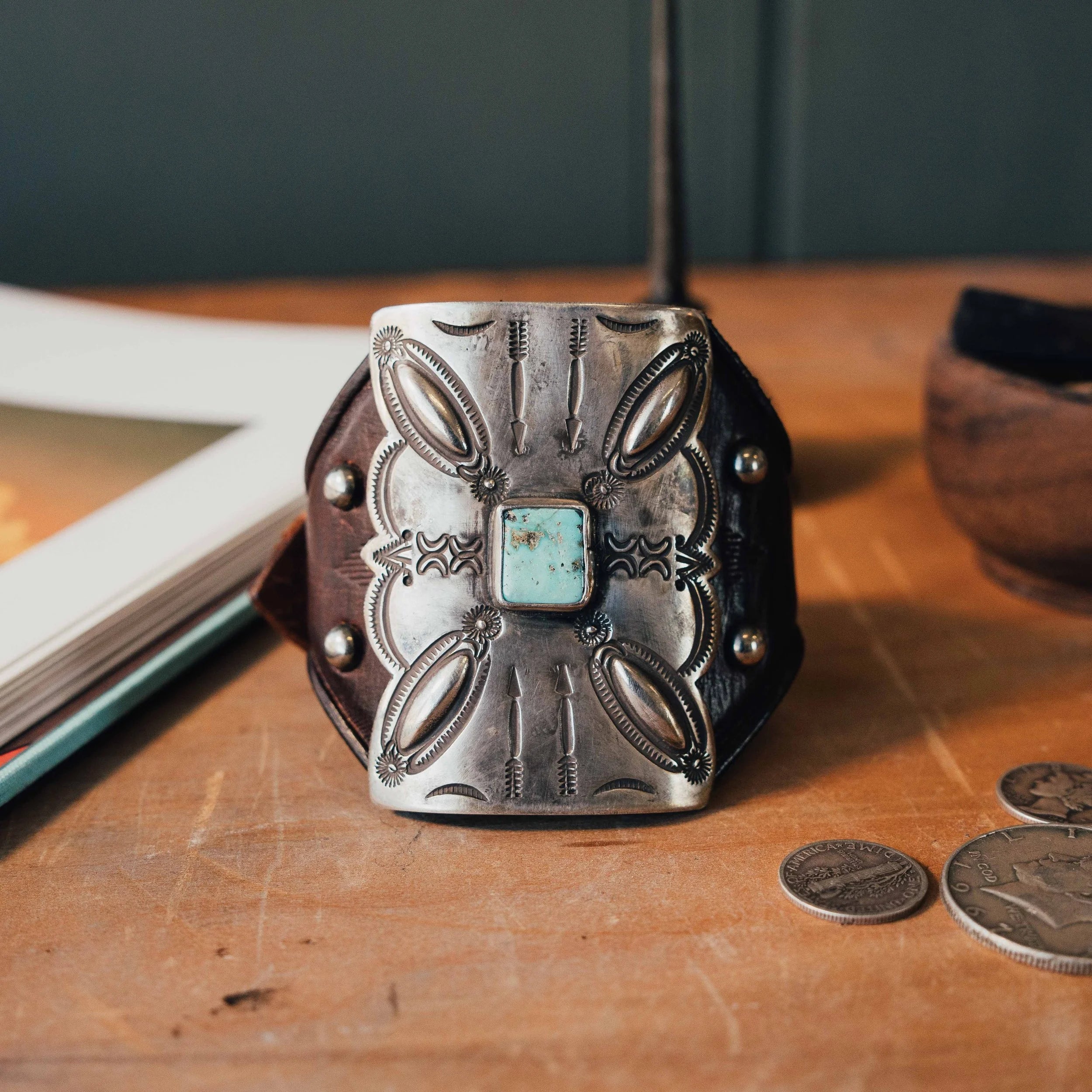 A coin silver bow guard ('ketoh') by the renowned silversmith Buffalo, on hand-tooled leather