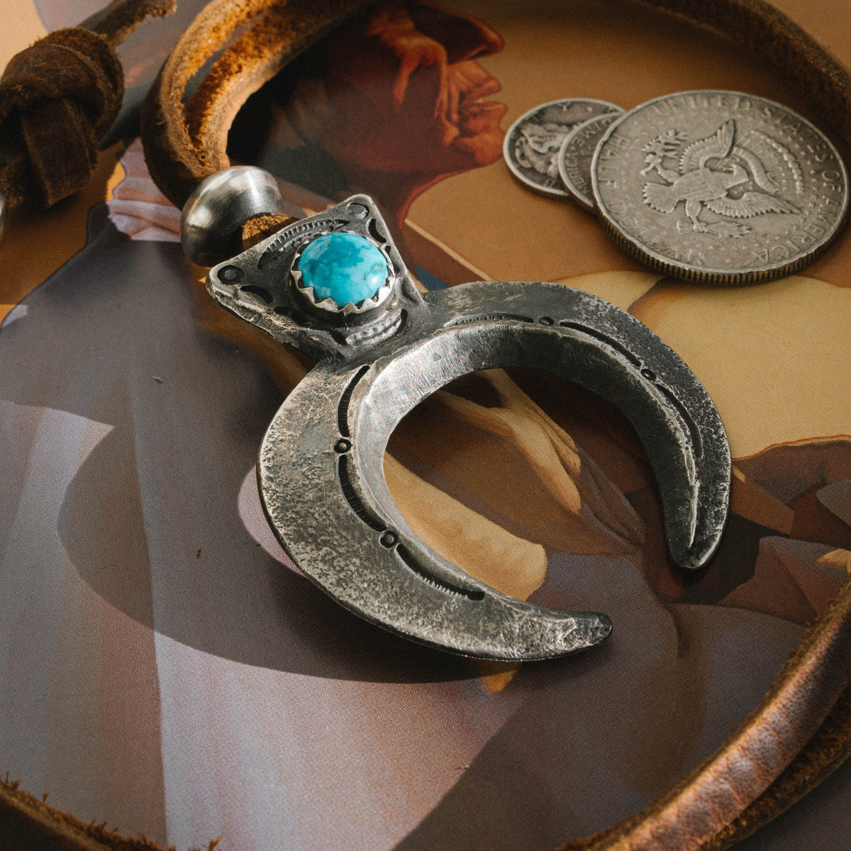 A tufa cast Naja pendant stamped with a set of our one-of-a-kind steel stamps set with a piece of high grade Kingman turquoise on brown leather cord — view 2