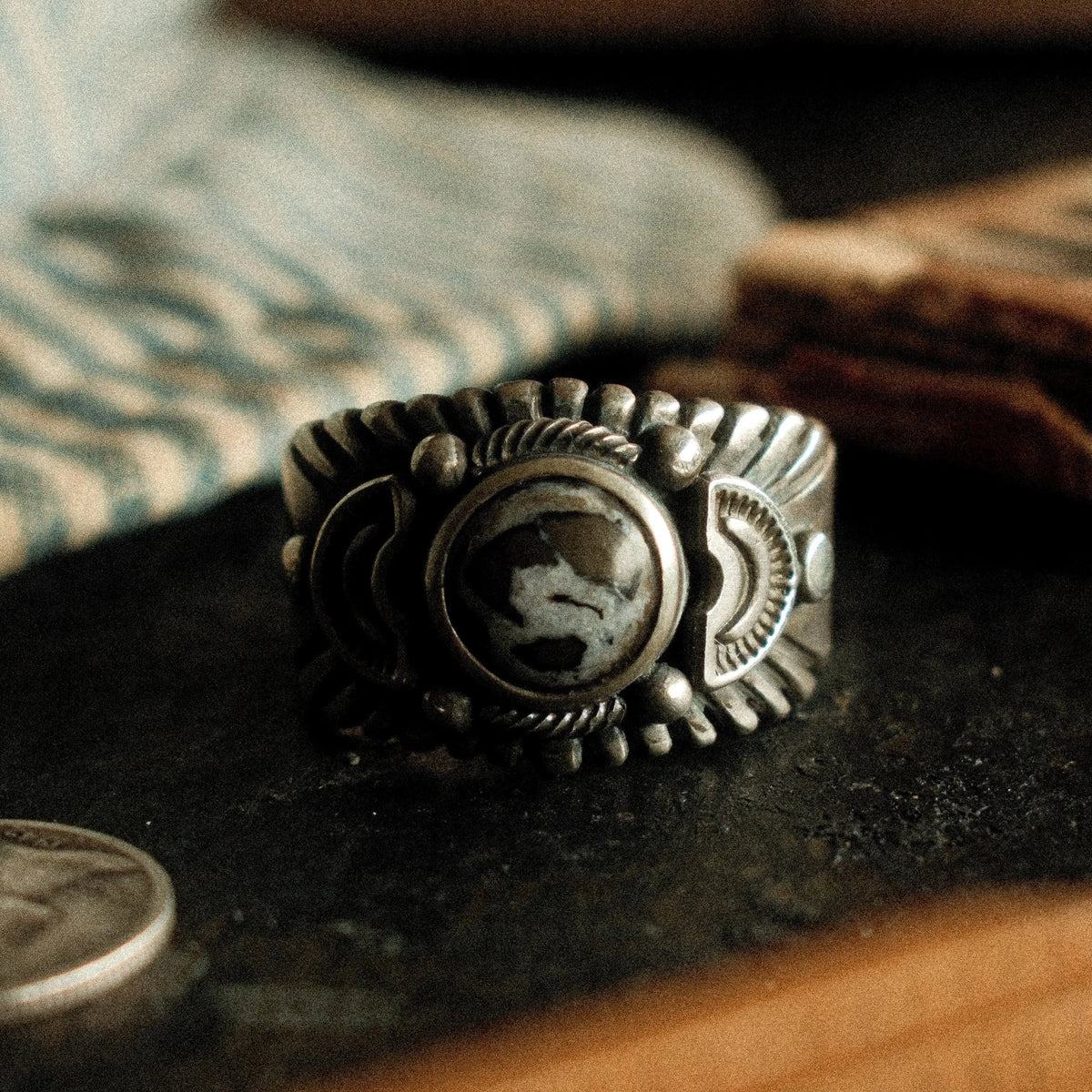 A premium 10mm White Buffalo stone on a heavy sterling Chief ring with hand-struck side detailing