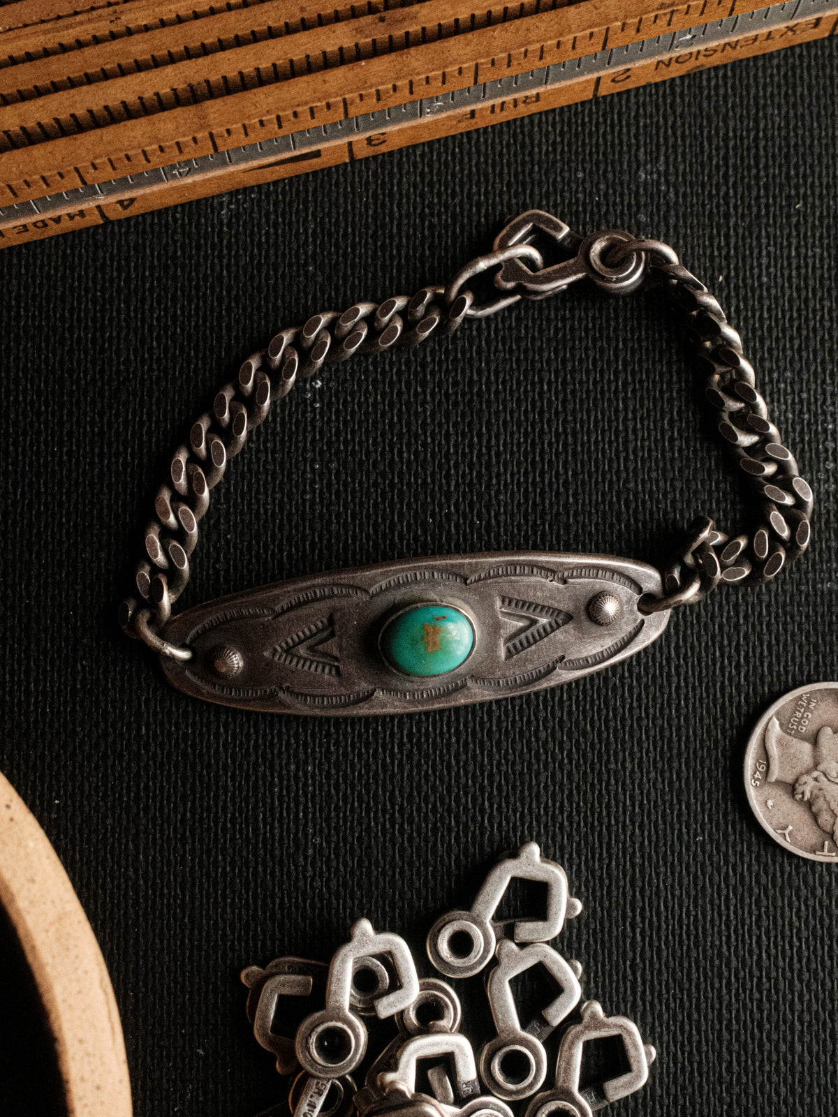 A hand-stamped ID plate set with Manassa turquoise on a sterling chain with a sister-hook clasp, finished in an aged patina