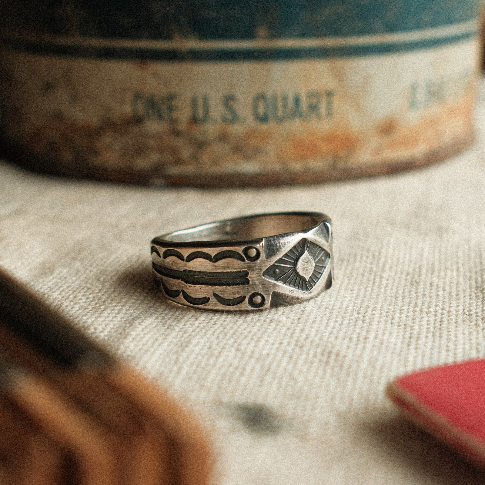 A diamond burst at center, hand-filed for dimension and bordered by slim arrows. Solid silver with a strong patina, made to your size.