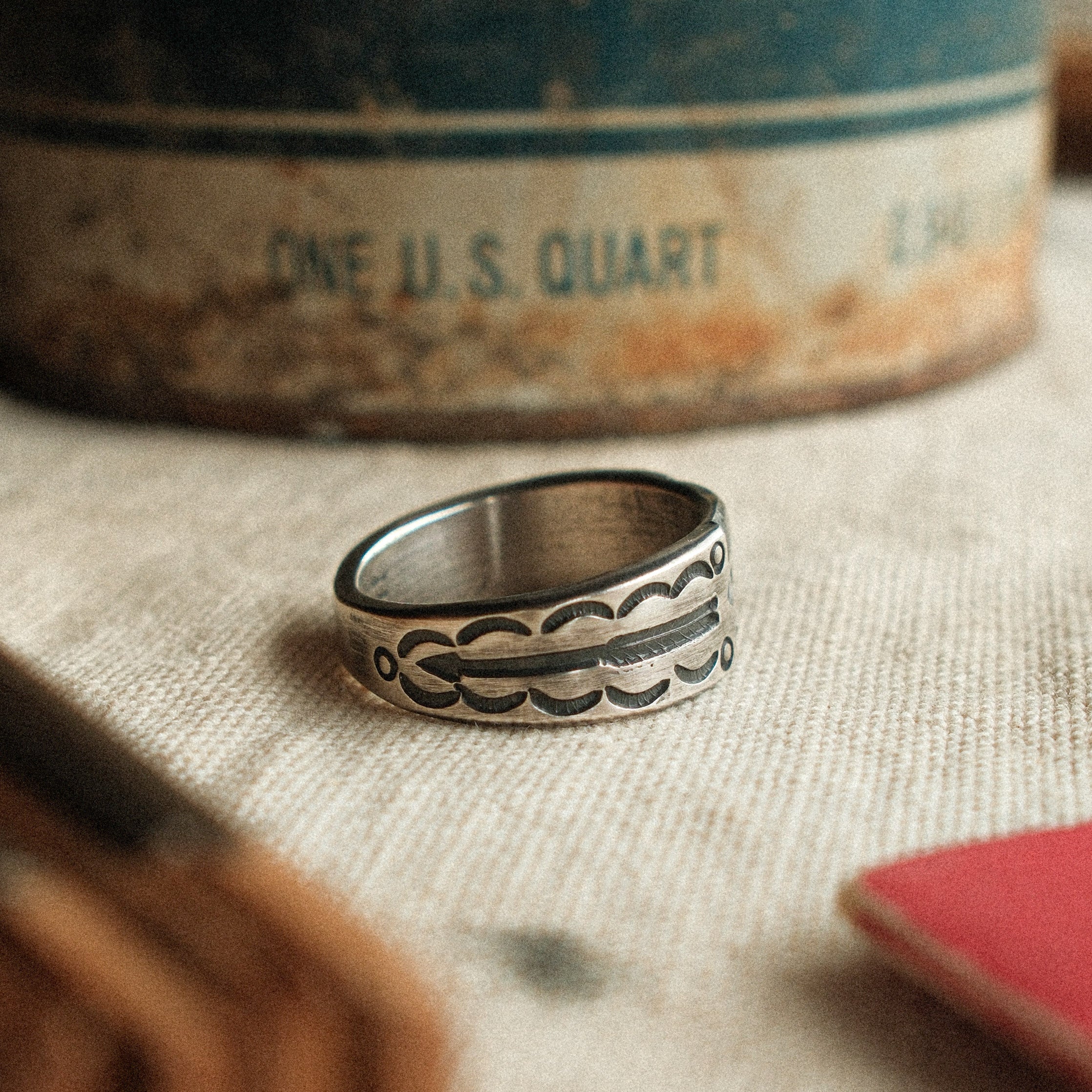 A diamond burst at center, hand-filed for dimension and bordered by slim arrows. Solid silver with a strong patina, made to your size.