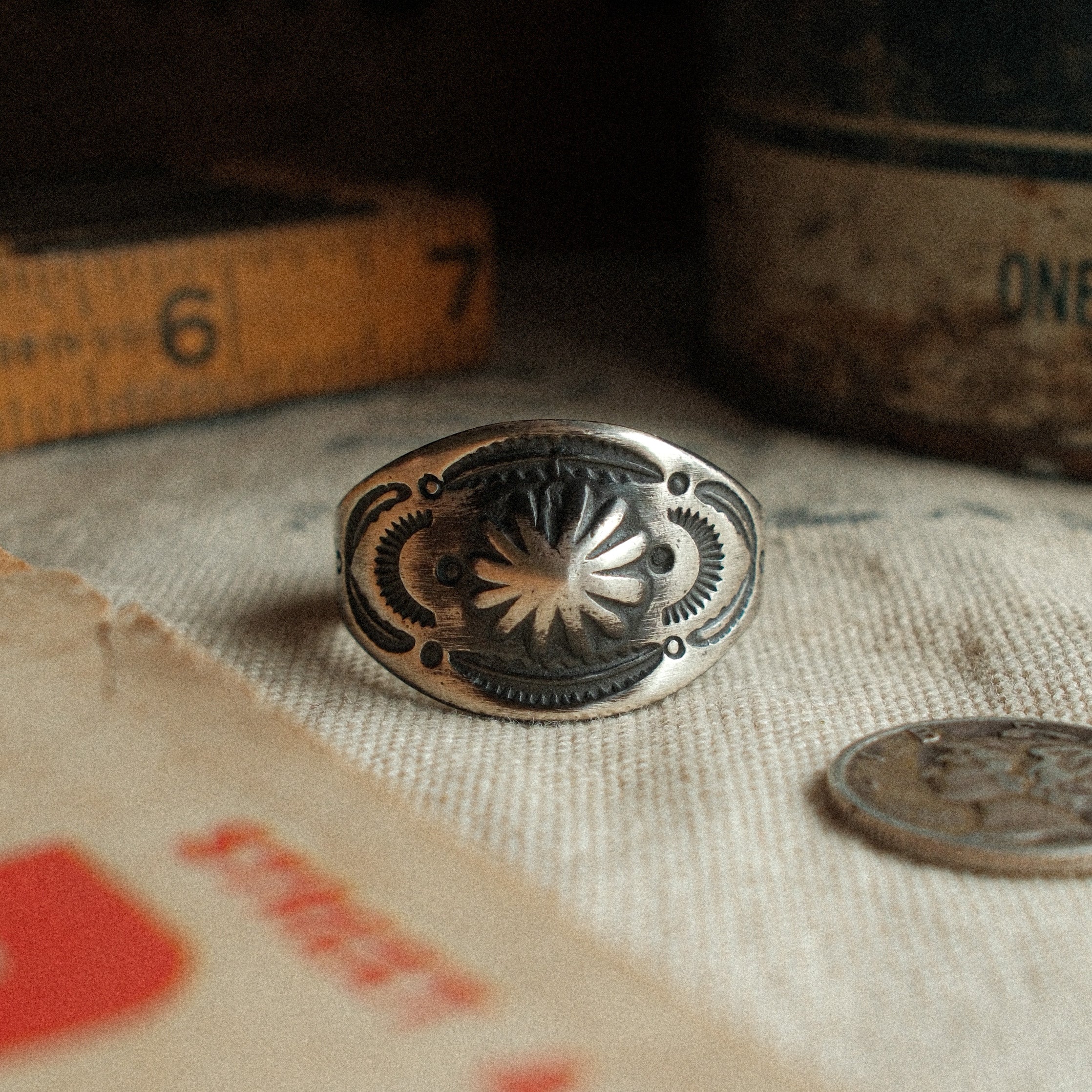 A vintage-inspired sterling cigar-band ring, hand-stamped with a 17mm top width and strong patina. Made to your size.