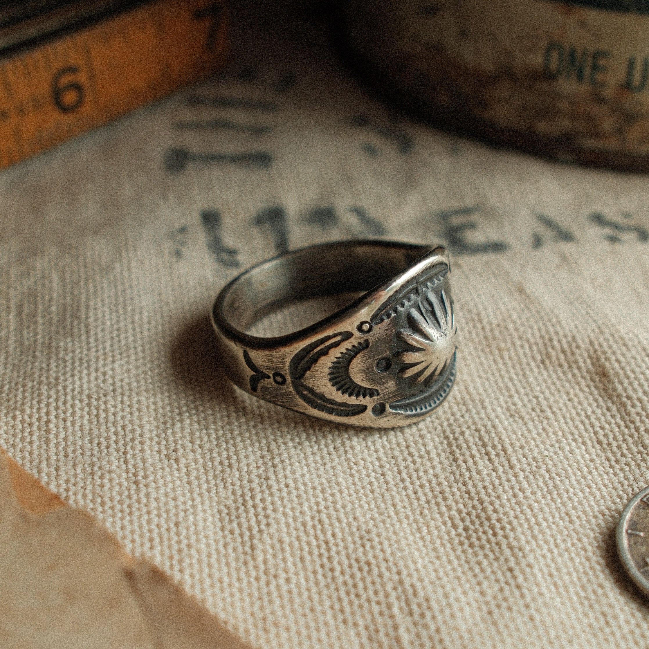 A vintage-inspired sterling cigar-band ring, hand-stamped with a 17mm top width and strong patina. Made to your size.
