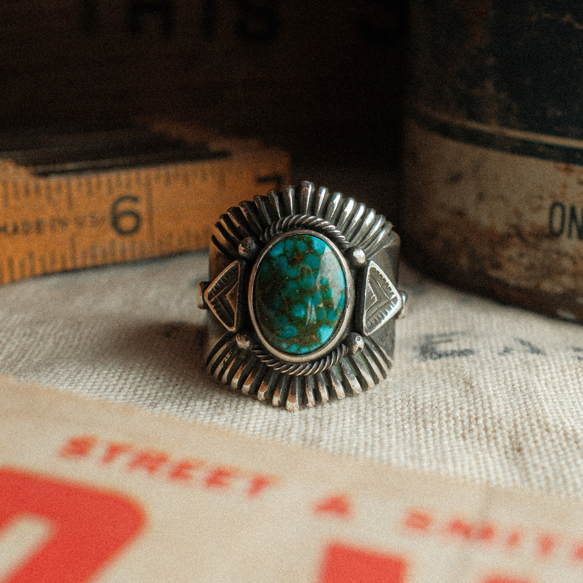 A high-grade Kingman Water Web turquoise cabochon set in a smooth bezel, framed by hand-stamped rays that fan out like a headdress