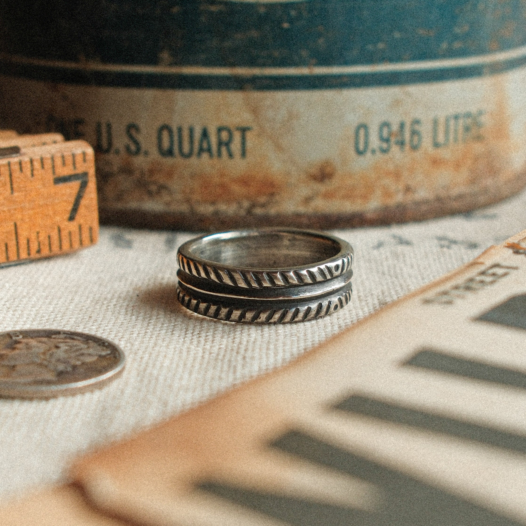 A 6mm hand-stamped sterling band with traditional pattern and real dimension — built as a forever wedding band or everyday ring.
