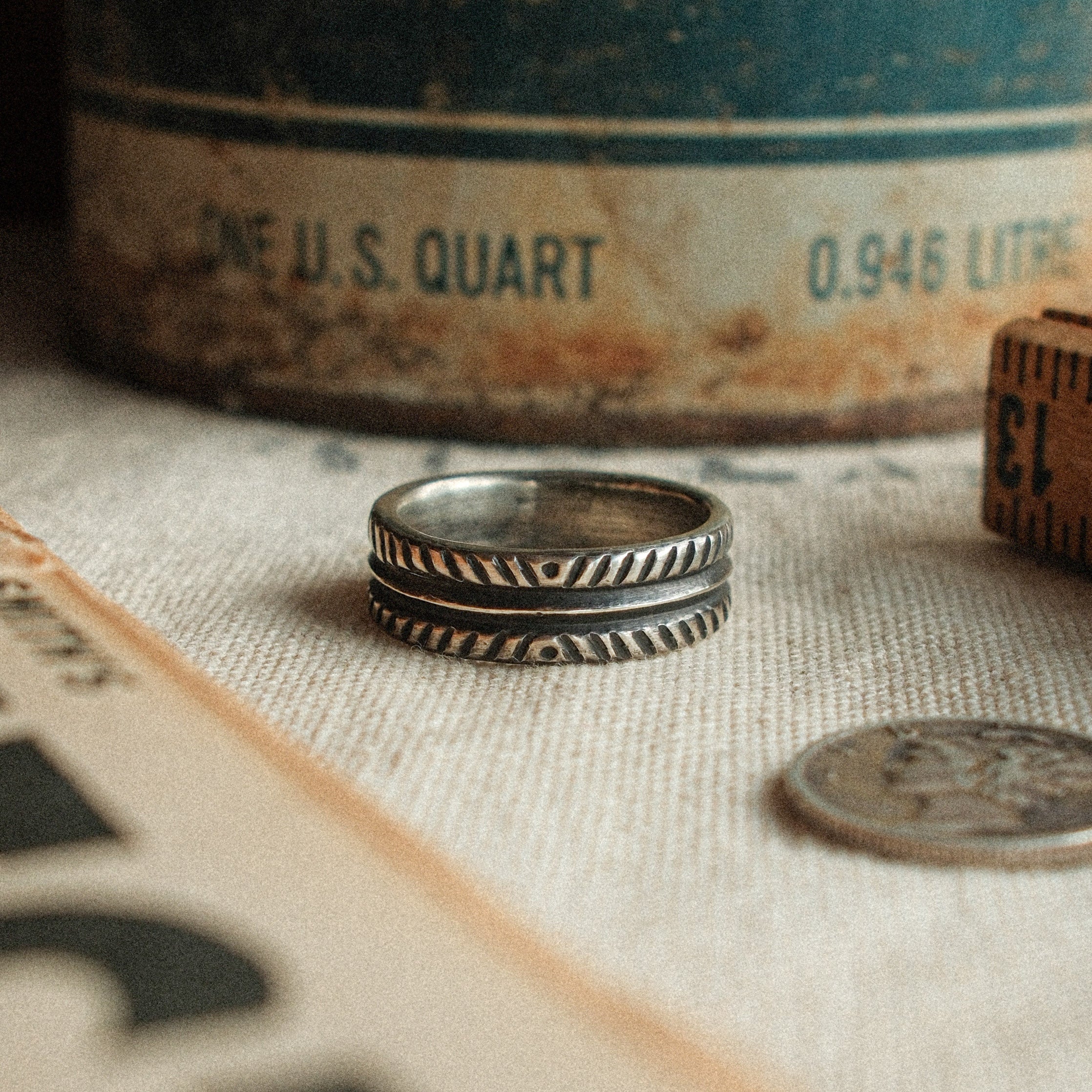 A 6mm hand-stamped sterling band with traditional pattern and real dimension — built as a forever wedding band or everyday ring.