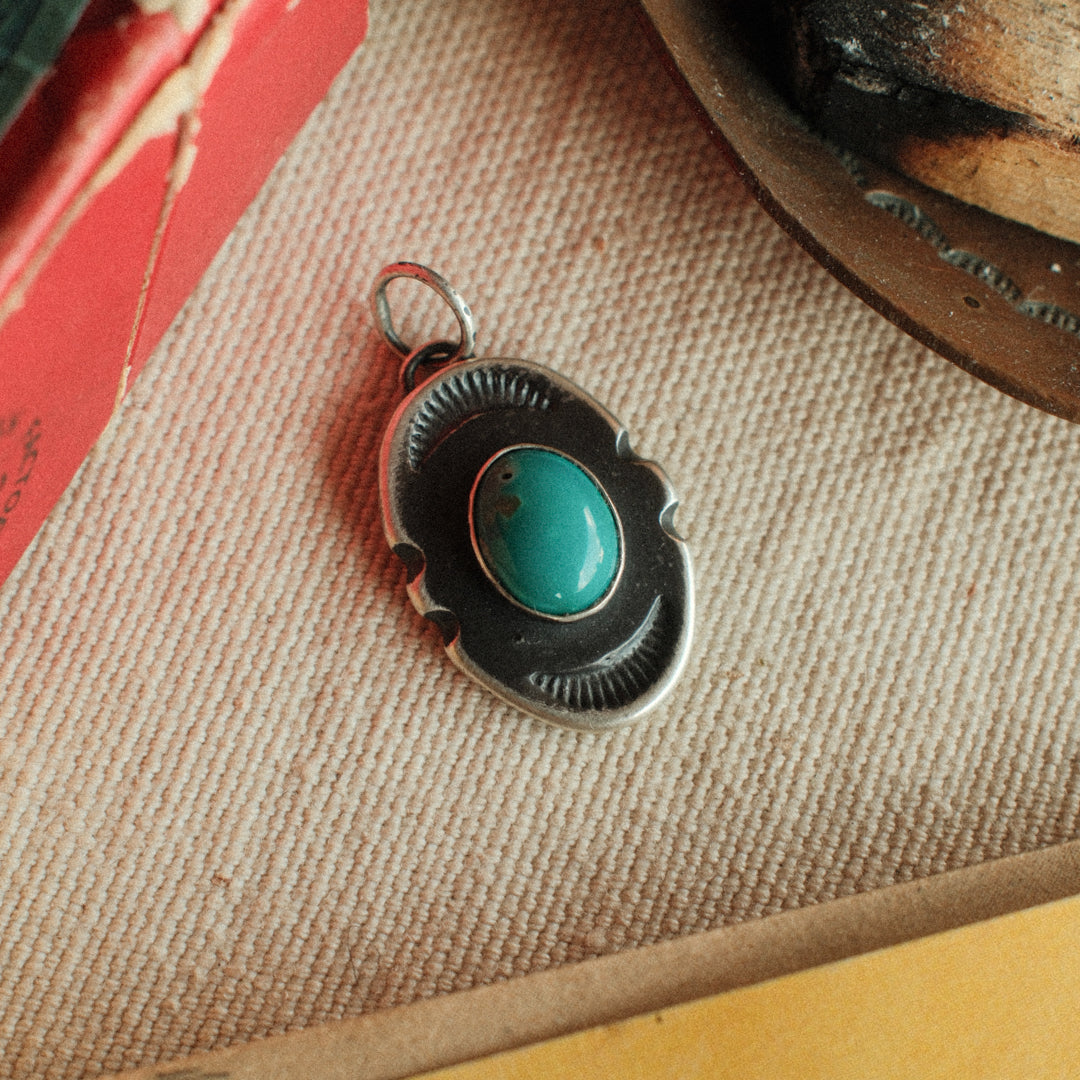 An oval sterling silver shield pendant with notched sides, set with sea-green Carico Lake turquoise — view 3