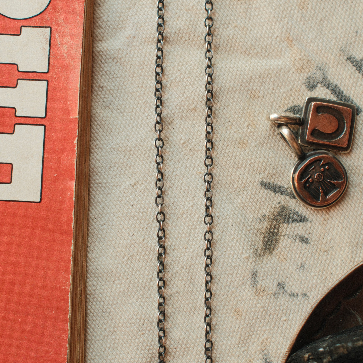 A 2.4mm sterling silver cable chain in 20 to 30 inch lengths, hand-finished with a strong patina and closed with a lobster clasp.