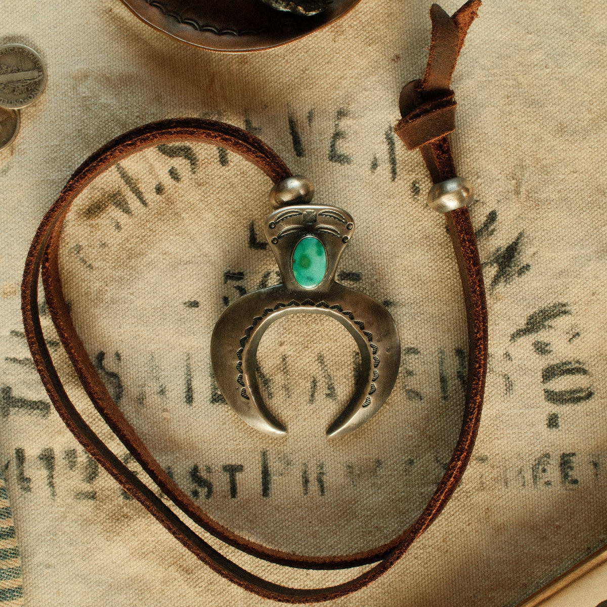 A one-of-a-kind tufa-cast Naja, thunderbird-stamped and set with a 9×15mm premium piece of Fox turquoise, on brown leather with two handmade silver adjusting beads — view 2