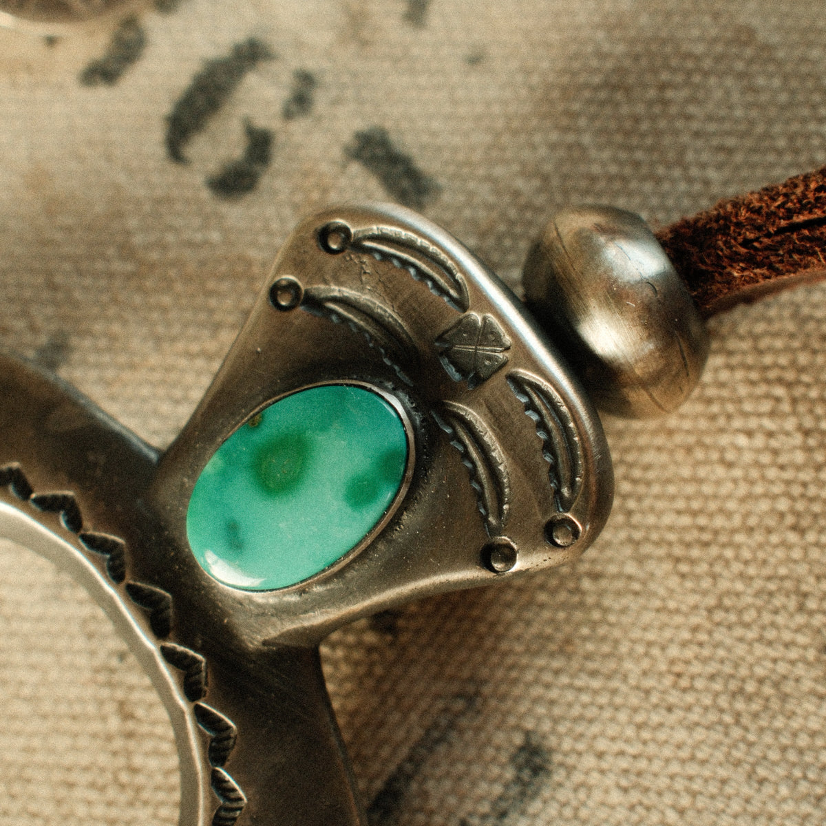 A one-of-a-kind tufa-cast Naja, thunderbird-stamped and set with a 9×15mm premium piece of Fox turquoise, on brown leather with two handmade silver adjusting beads — view 3