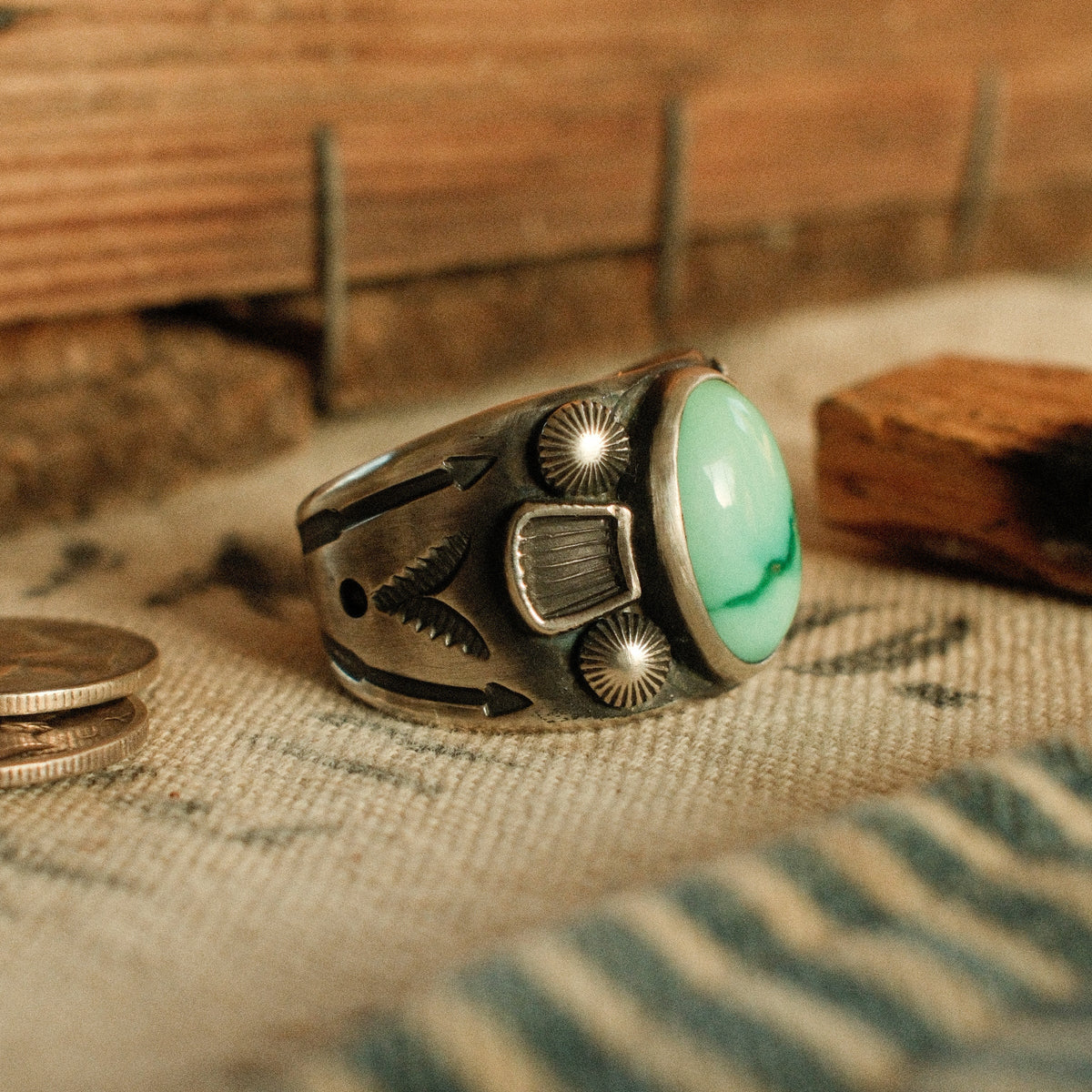 A one-of-a-kind 10×15mm Fox turquoise in a smooth bezel between stamped panels and starburst conchos, on a wide tapering band — view 2