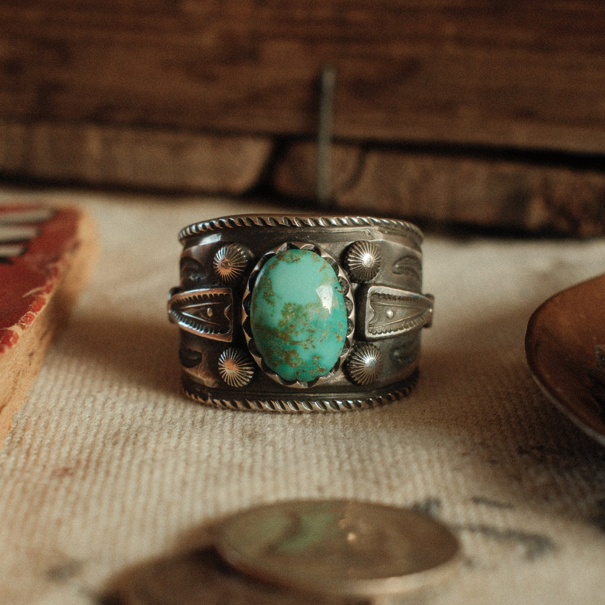 A one-of-a-kind 9×13mm Fox turquoise in a filed serrated bezel with stamped arrowhead panels, starburst conchos, channel work and a hatched border