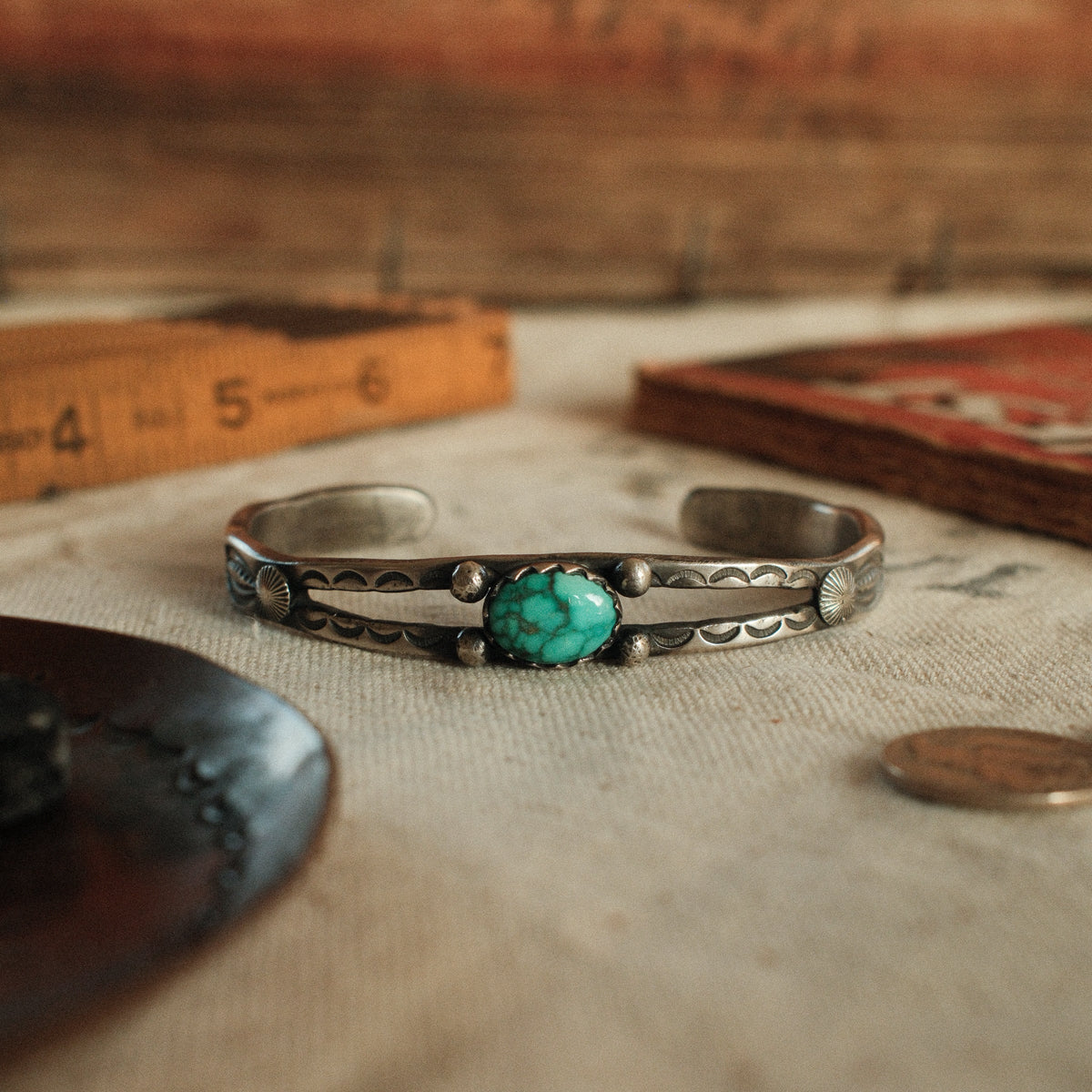 A one-of-a-kind tufa-cast split cuff with an 8×12mm Fox turquoise in a hand filed serrated bezel, between silver beads on twin bars
