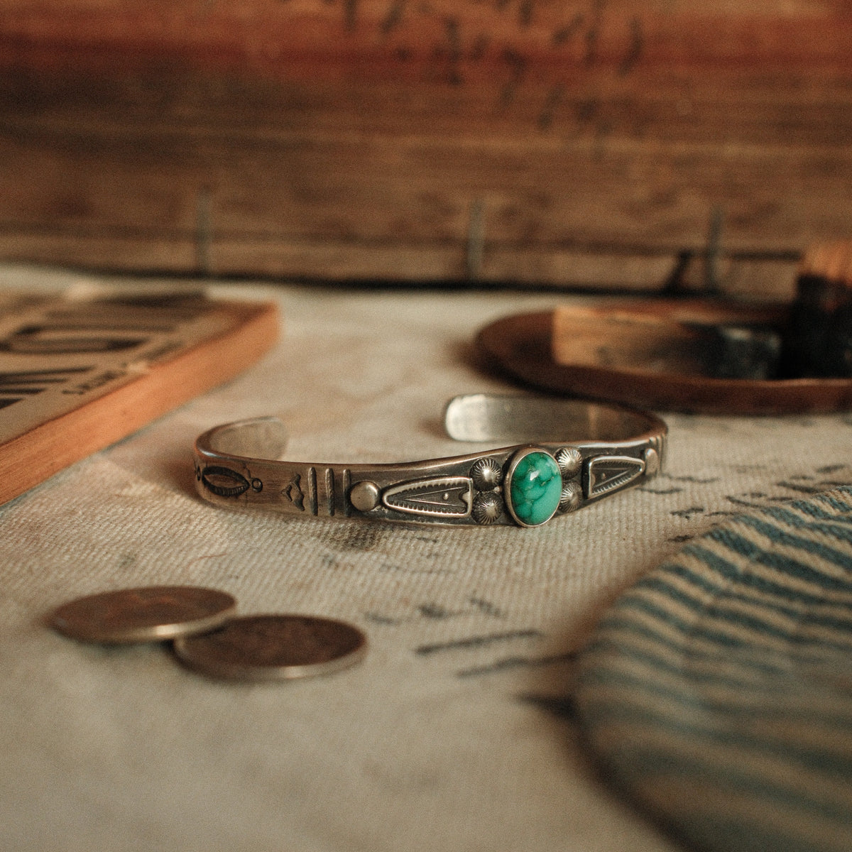 A one-of-a-kind tufa-cast stacking cuff with a 7×9mm Fox turquoise in a hand filed serrated bezel between stamped arrowhead panels — view 2