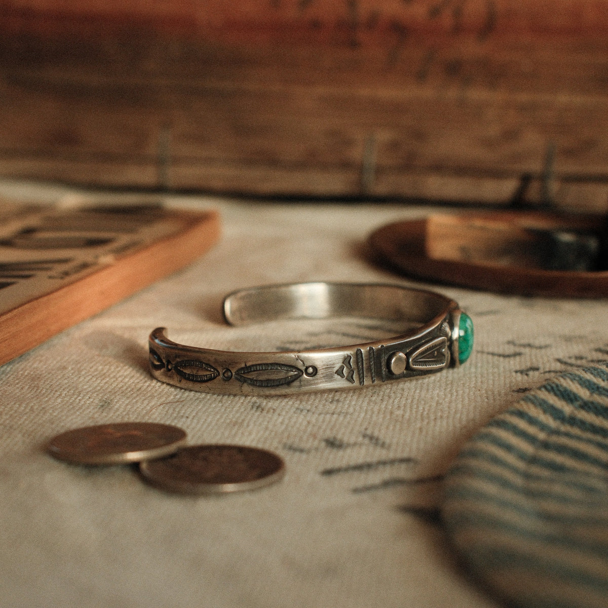 A one-of-a-kind tufa-cast stacking cuff with a 7×9mm Fox turquoise in a hand filed serrated bezel between stamped arrowhead panels — view 4
