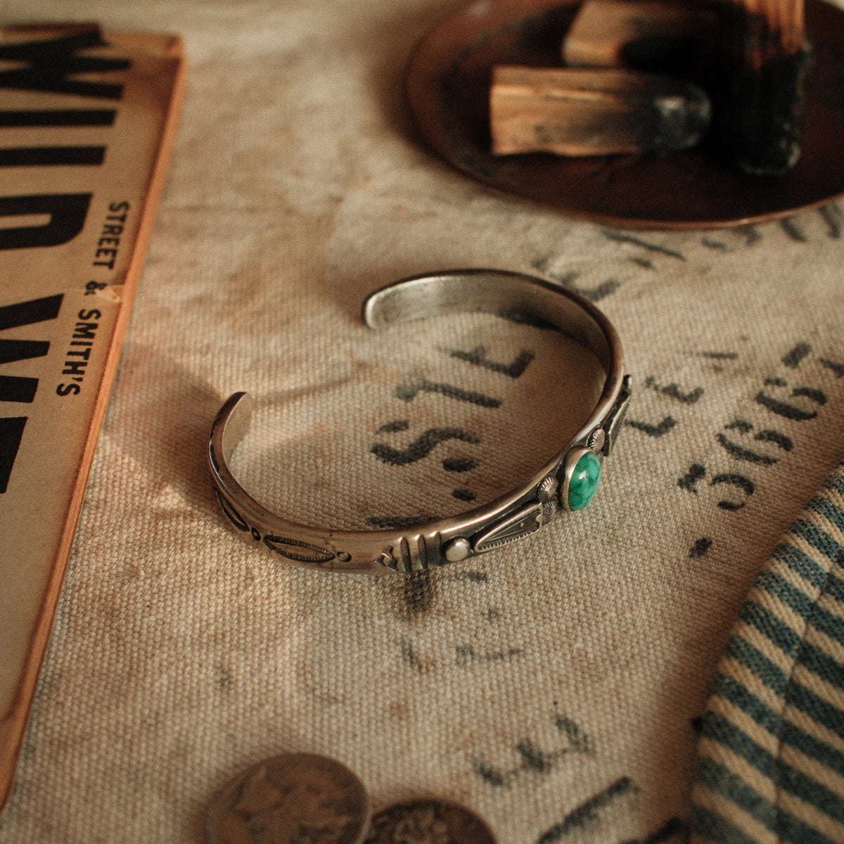 A one-of-a-kind tufa-cast stacking cuff with a 7×9mm Fox turquoise in a hand filed serrated bezel between stamped arrowhead panels — view 6