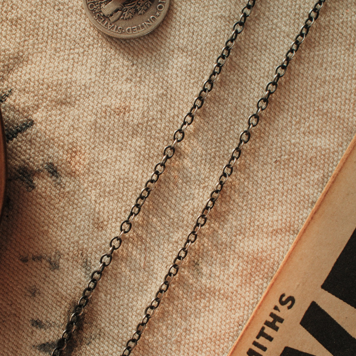 A 2.4mm sterling silver cable chain in 20 to 30 inch lengths, hand-finished with a strong patina and closed with a lobster clasp.