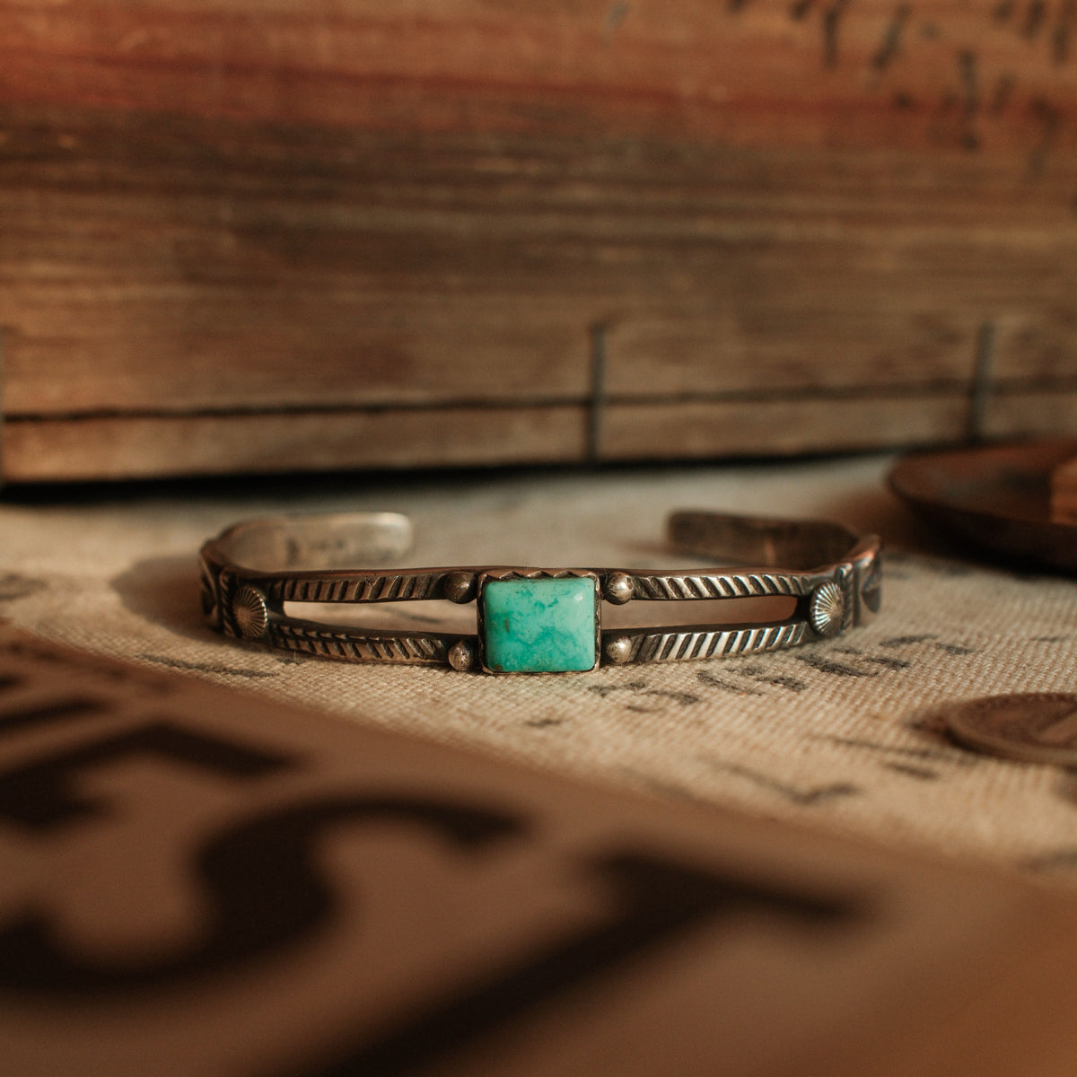 A one-of-a-kind tufa-cast split cuff with an 8×10mm Fox turquoise in a hand filed serrated bezel between twin hatched bars