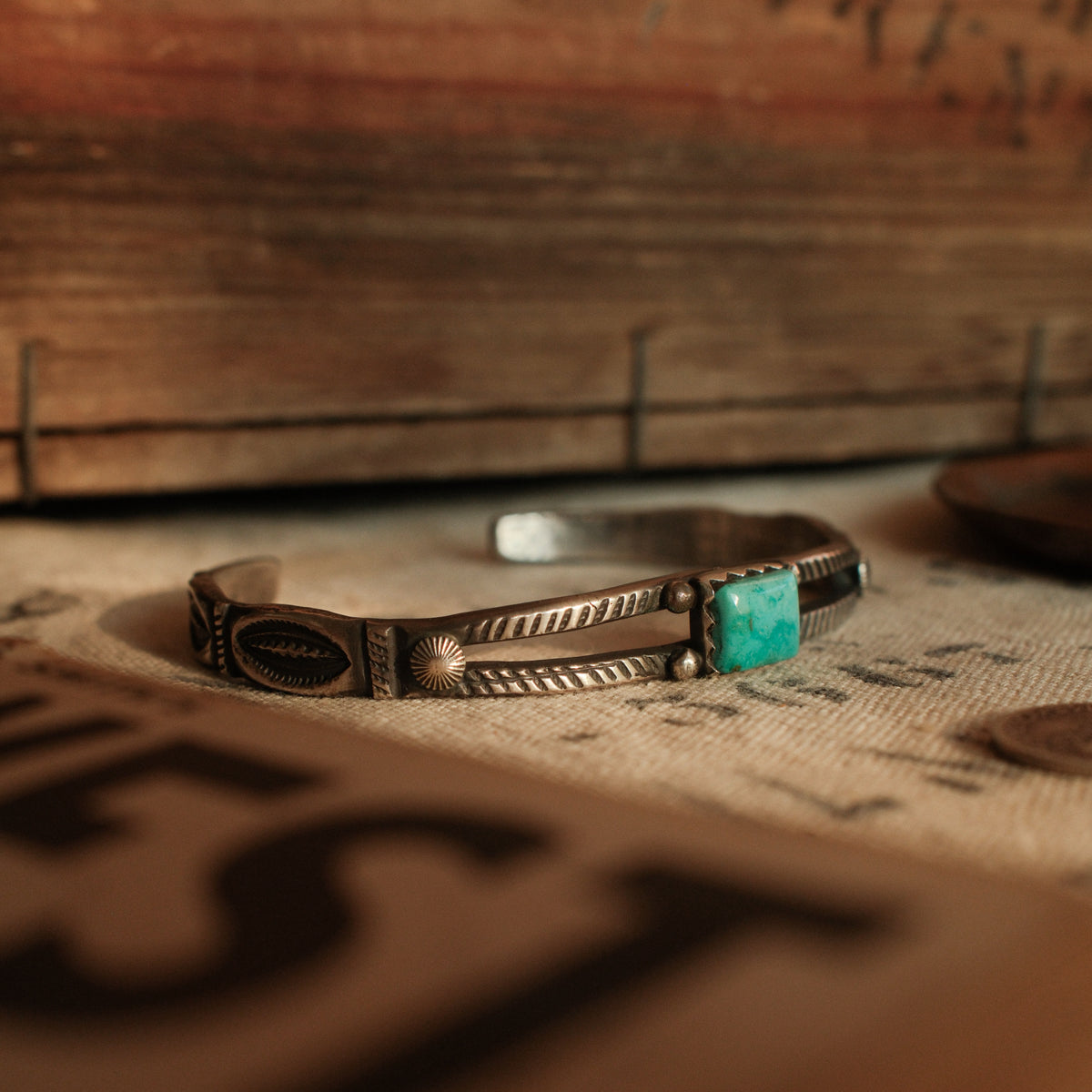 A one-of-a-kind tufa-cast split cuff with an 8×10mm Fox turquoise in a hand filed serrated bezel between twin hatched bars — view 2