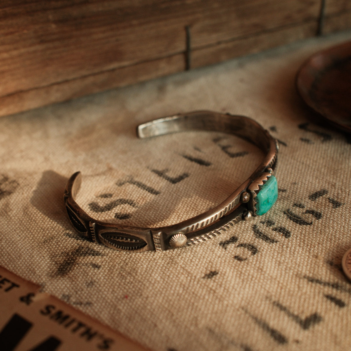 A one-of-a-kind tufa-cast split cuff with an 8×10mm Fox turquoise in a hand filed serrated bezel between twin hatched bars — view 4