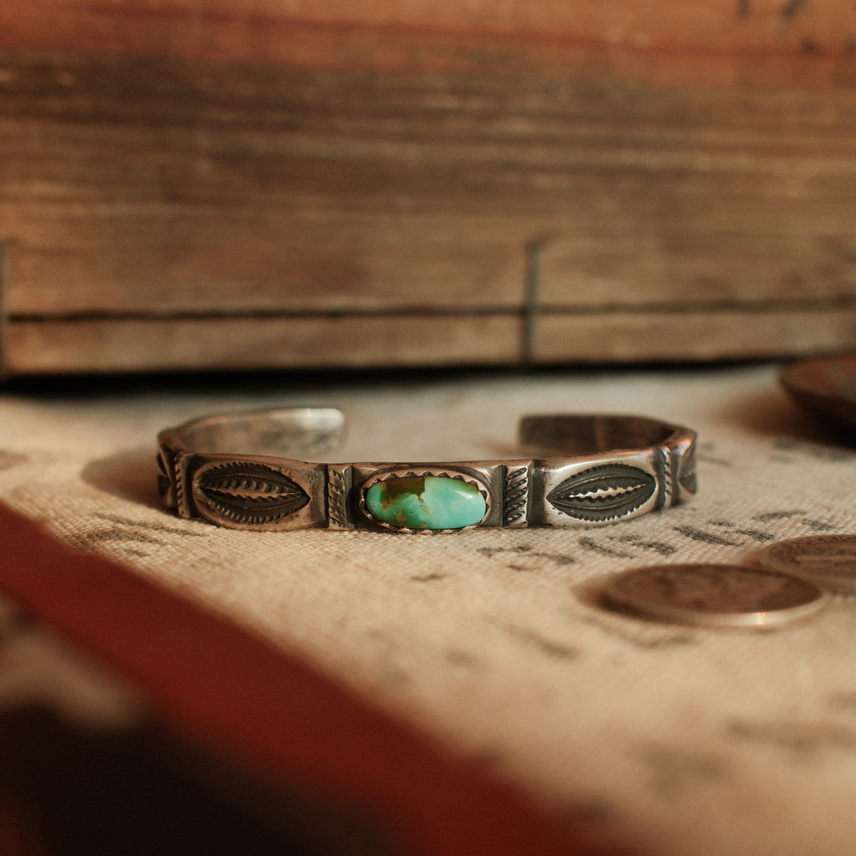 A one-of-a-kind tufa-cast stacking cuff with a 5×12mm Fox turquoise in a hand filed serrated bezel, large arrows struck inside each terminal