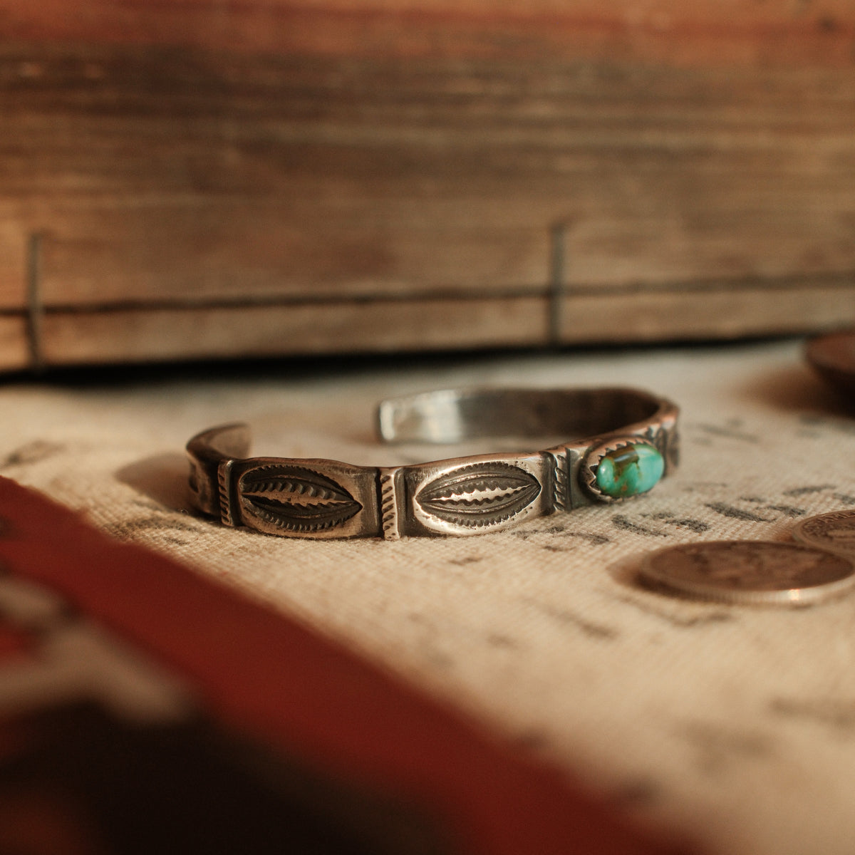 A one-of-a-kind tufa-cast stacking cuff with a 5×12mm Fox turquoise in a hand filed serrated bezel, large arrows struck inside each terminal — view 2