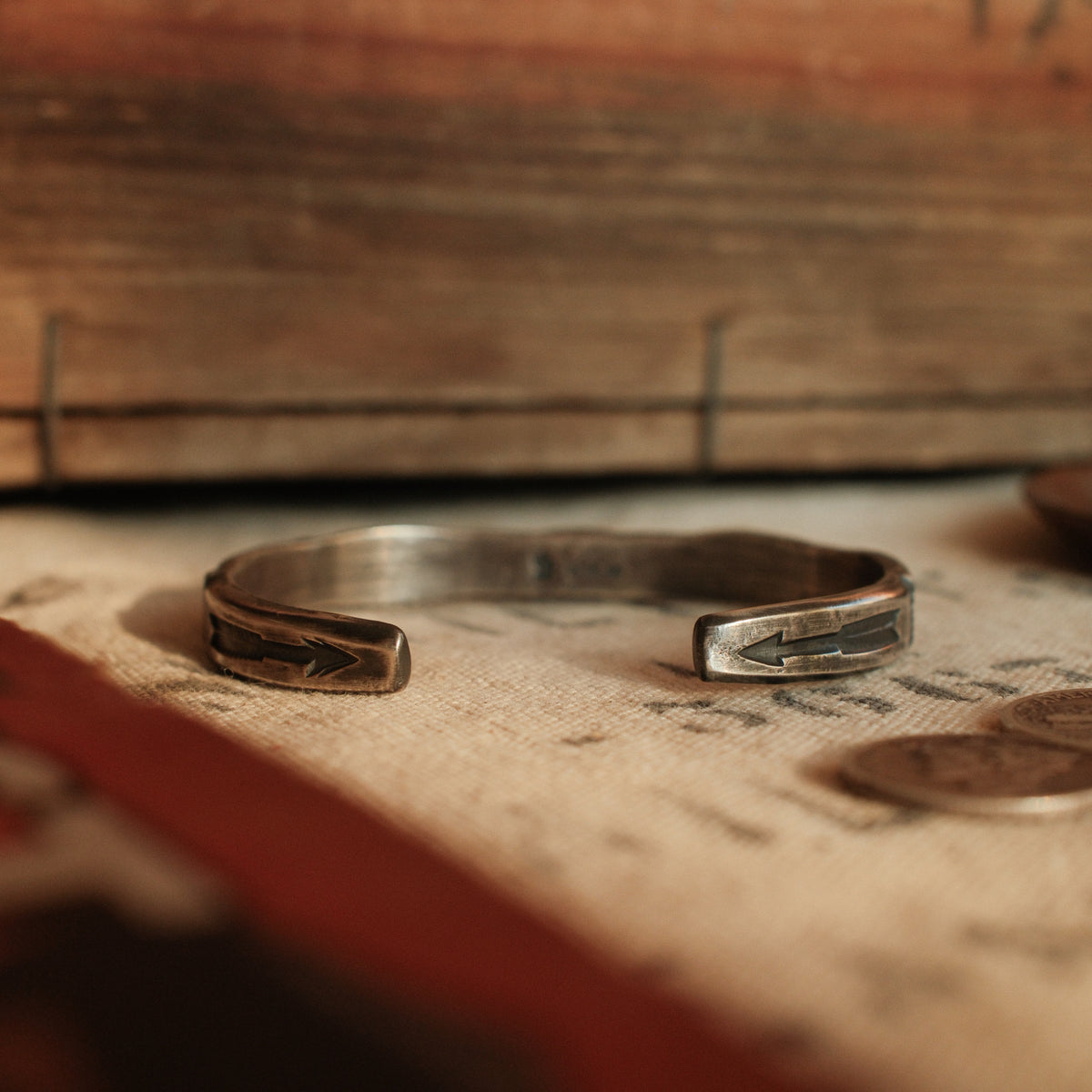 A one-of-a-kind tufa-cast stacking cuff with a 5×12mm Fox turquoise in a hand filed serrated bezel, large arrows struck inside each terminal — view 4