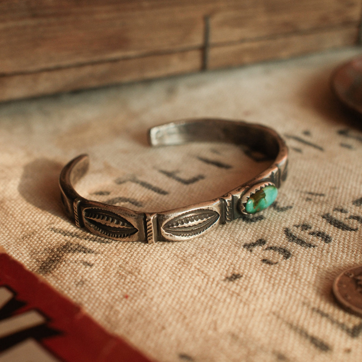 A one-of-a-kind tufa-cast stacking cuff with a 5×12mm Fox turquoise in a hand filed serrated bezel, large arrows struck inside each terminal — view 5