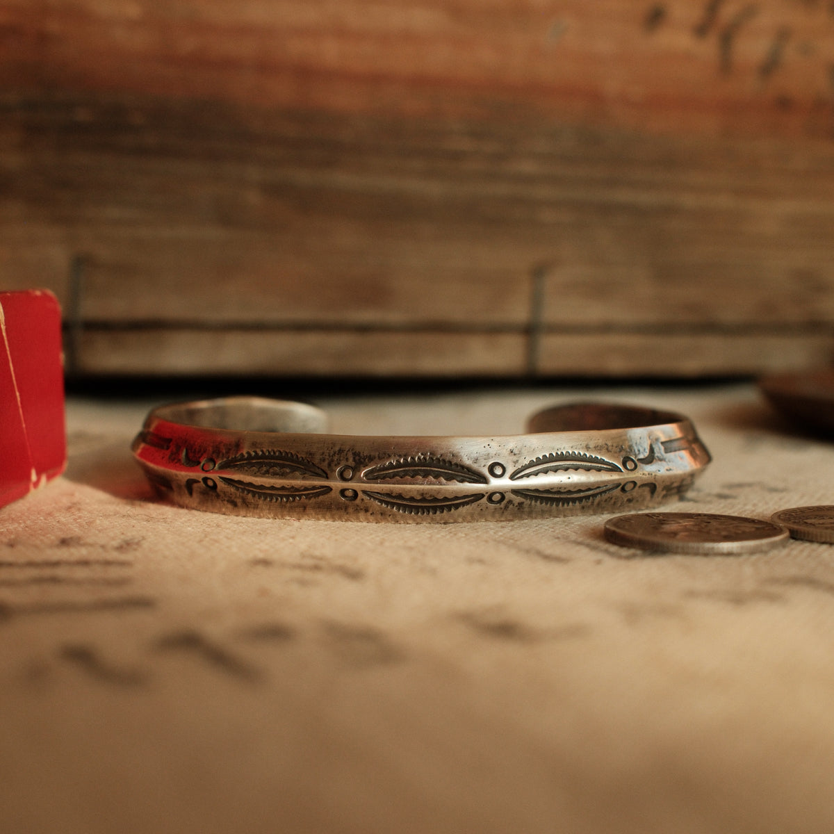 A one-of-a-kind triangular cuff forged from a tufa-cast sterling ingot with the casting texture intact, deeply stamped with arrows at each terminal