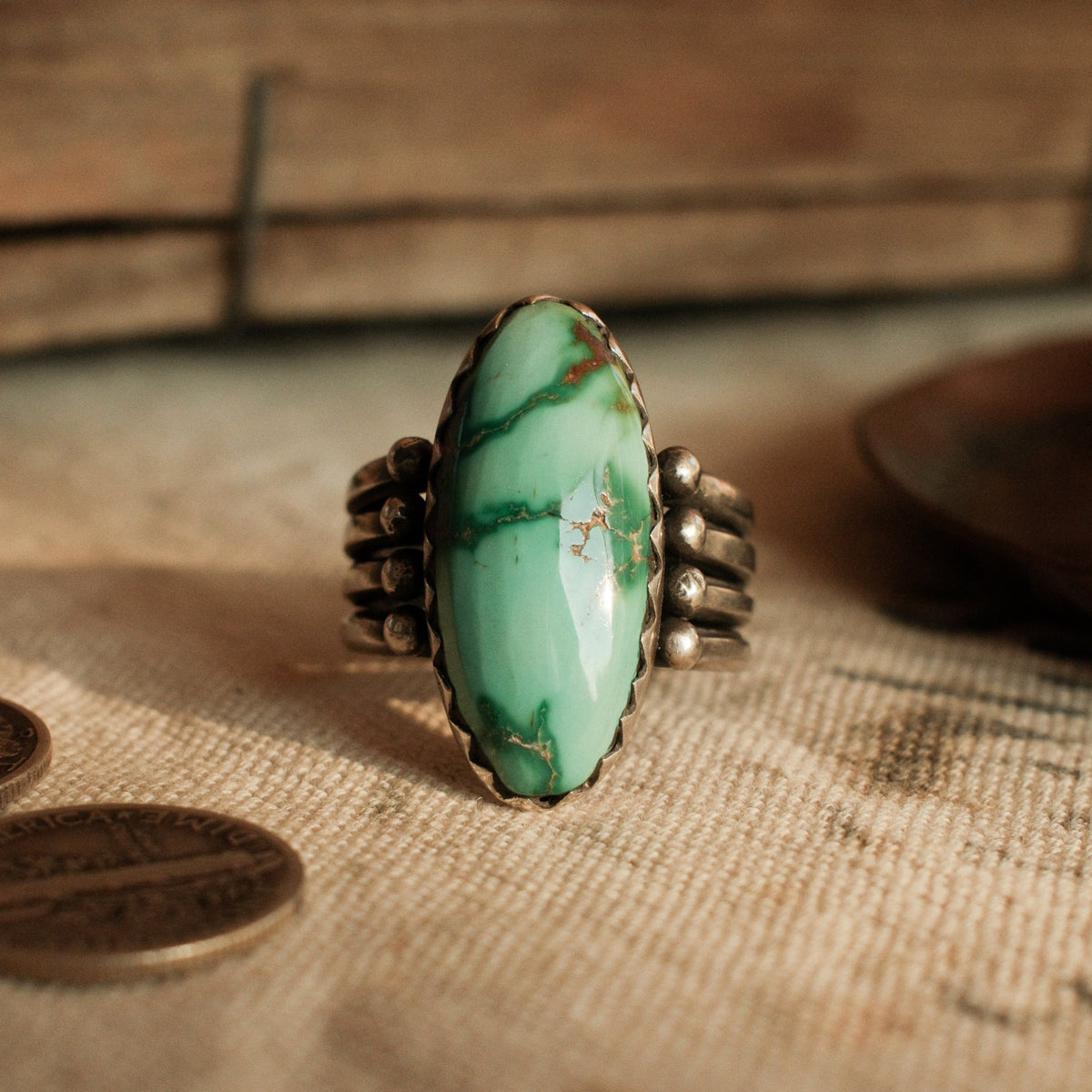 A one-of-a-kind 12×26mm Fox turquoise in a hand filed serrated bezel on a four-prong split shank with stacked silver beads