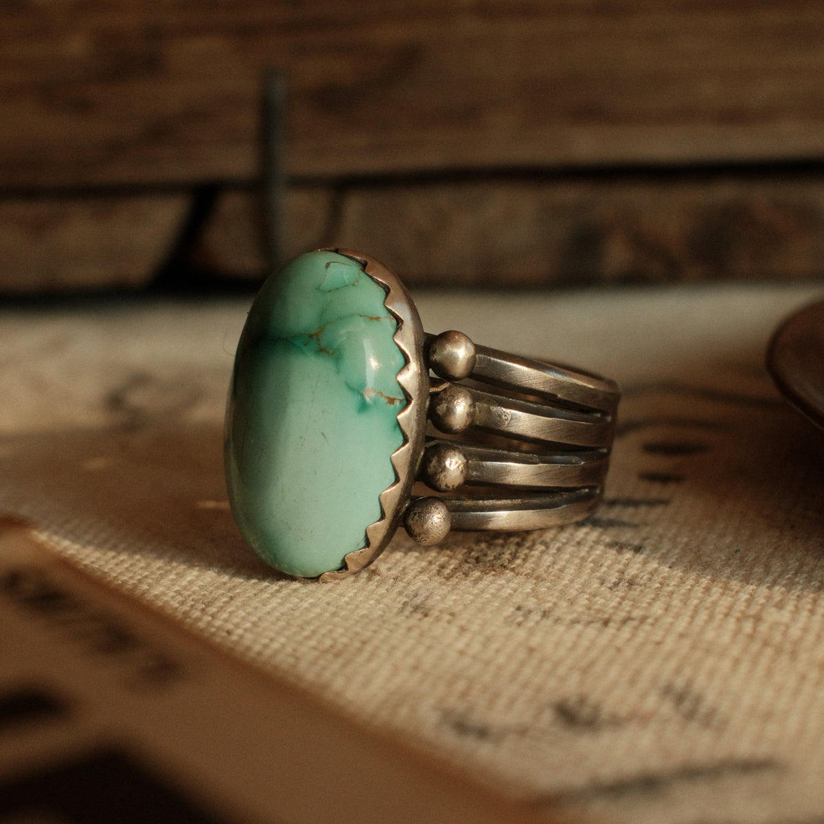 A one-of-a-kind high-domed 12×20mm Fox turquoise in a hand filed serrated bezel on a four-prong split shank, stamped on the back — view 5