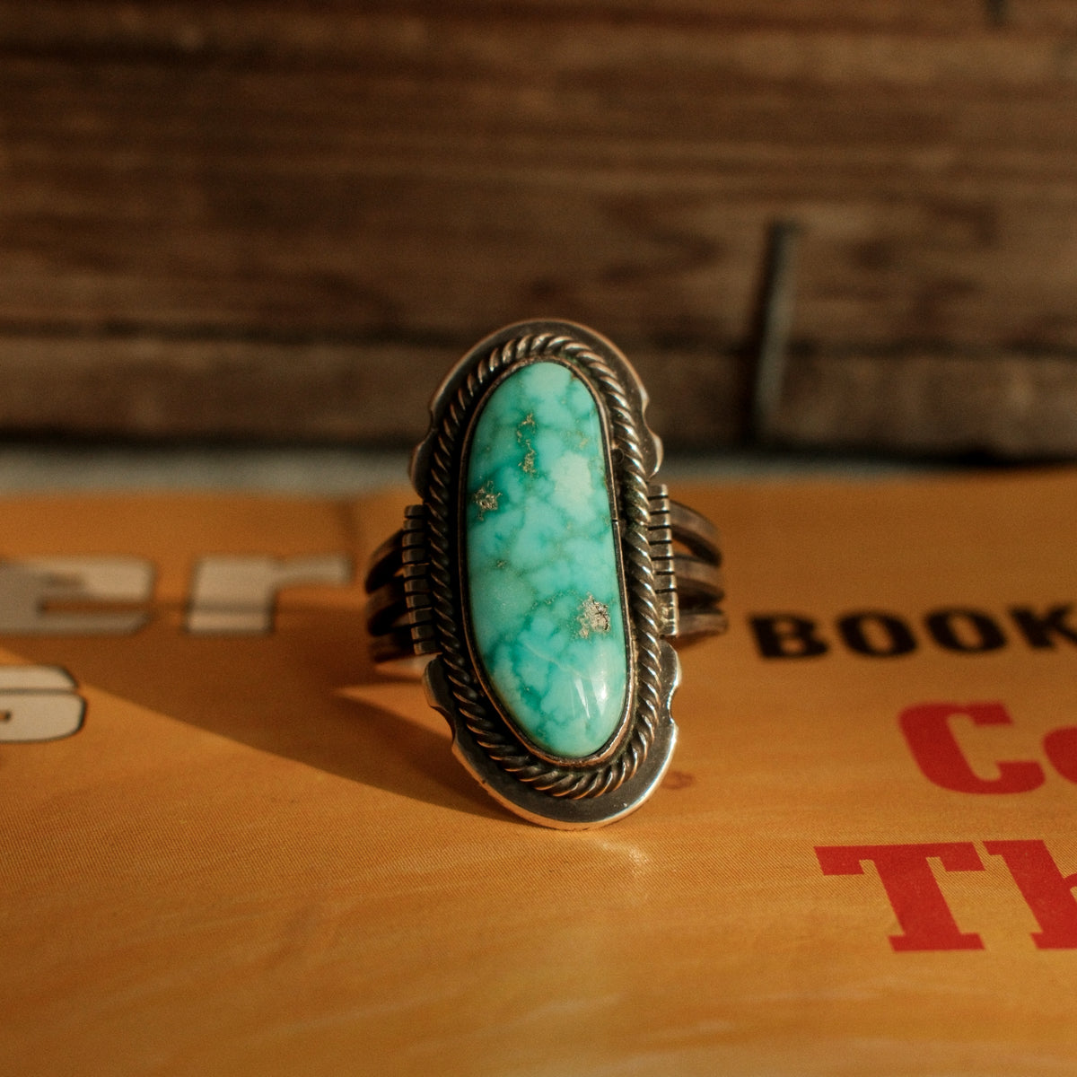 A one-of-a-kind 8×20mm Carico Lake turquoise in a straight bezel inside a twist wire border, on a three-prong stamped split shank
