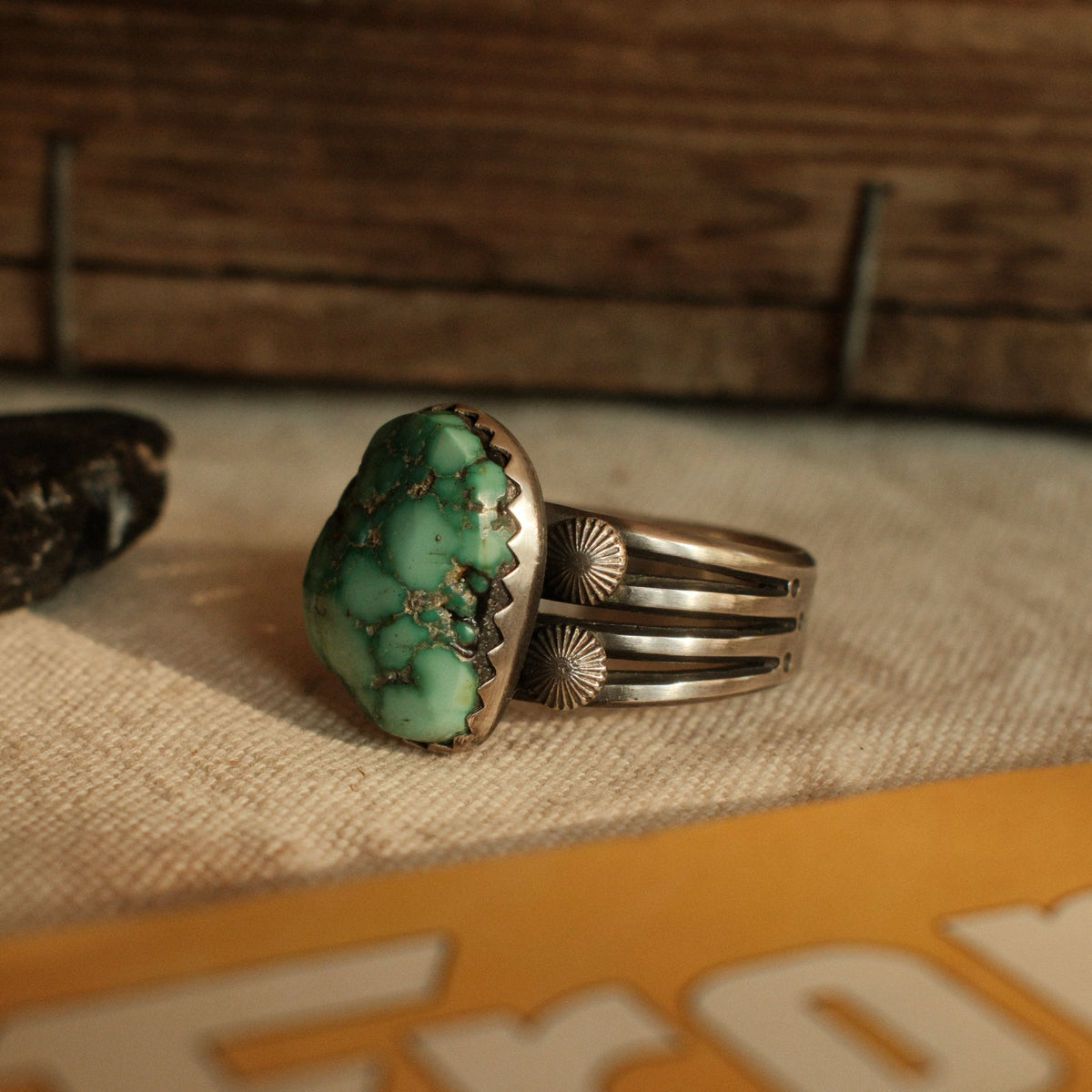 A one-of-a-kind 15×19mm nugget cut Fox turquoise in a hand filed serrated bezel on a four-prong split shank with starburst conchos, stamped across the back — view 4