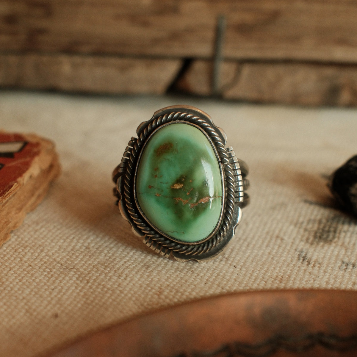 A one-of-a-kind 12×18mm Royston turquoise in a straight bezel inside a twist wire border, on a three-prong stamped split shank