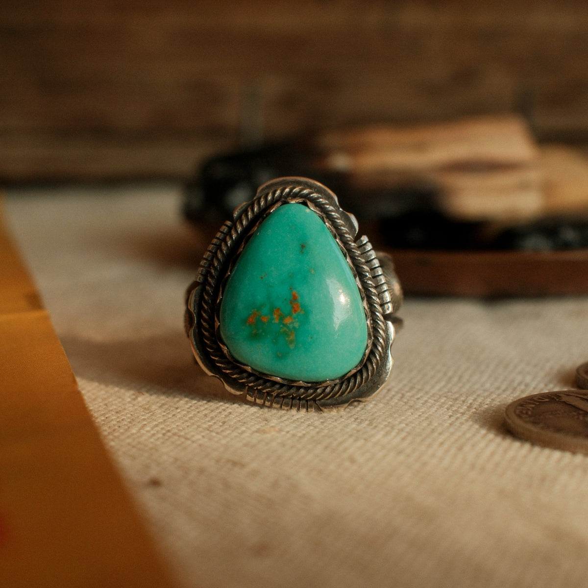 A one-of-a-kind 13×17mm Royston turquoise in a hand filed serrated bezel inside a twist wire border, conchos on the split shank, stamped across the back