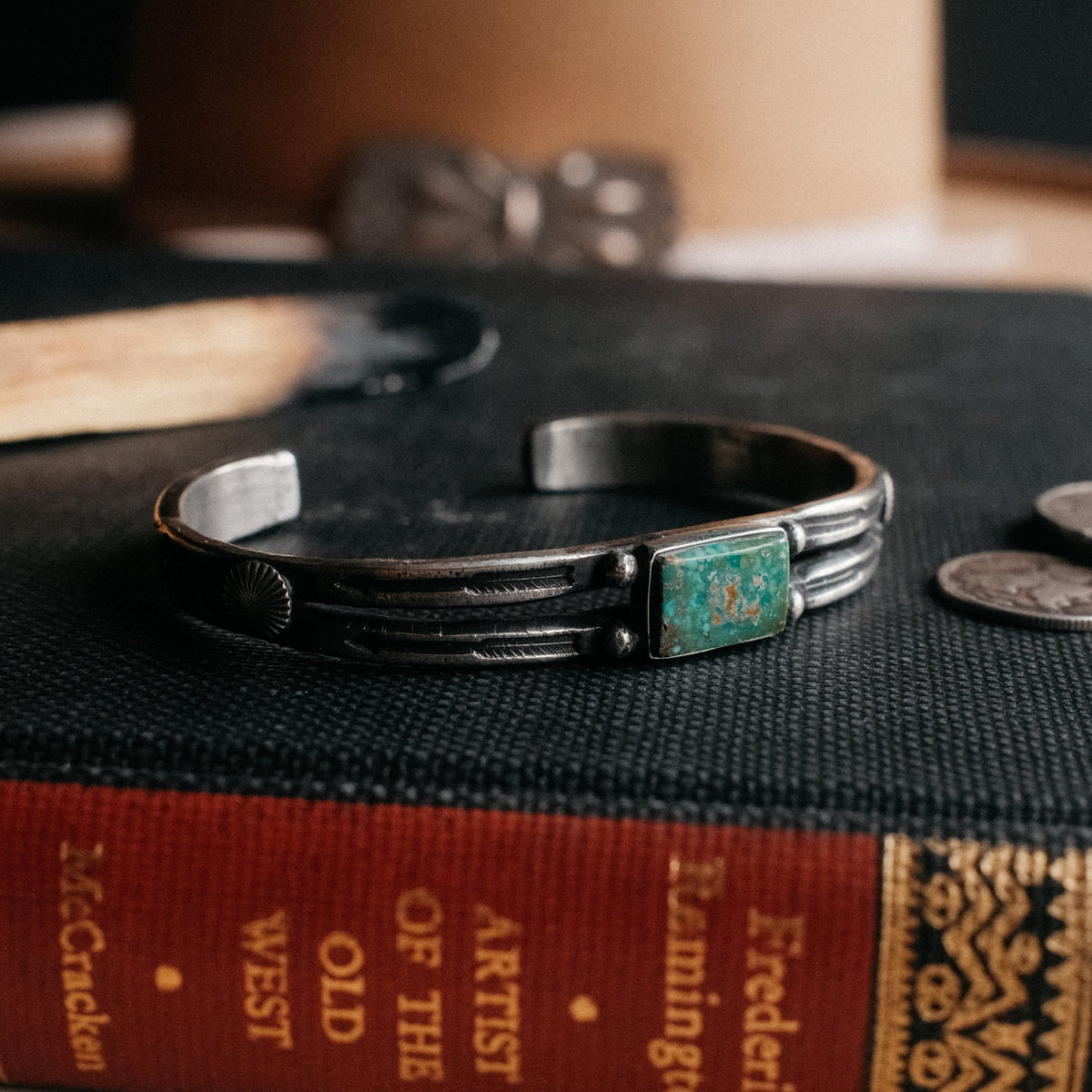 A split cuff poured from a tufa-cast ingot and hand-stamped, set with Royston turquoise from Nevada — view 3