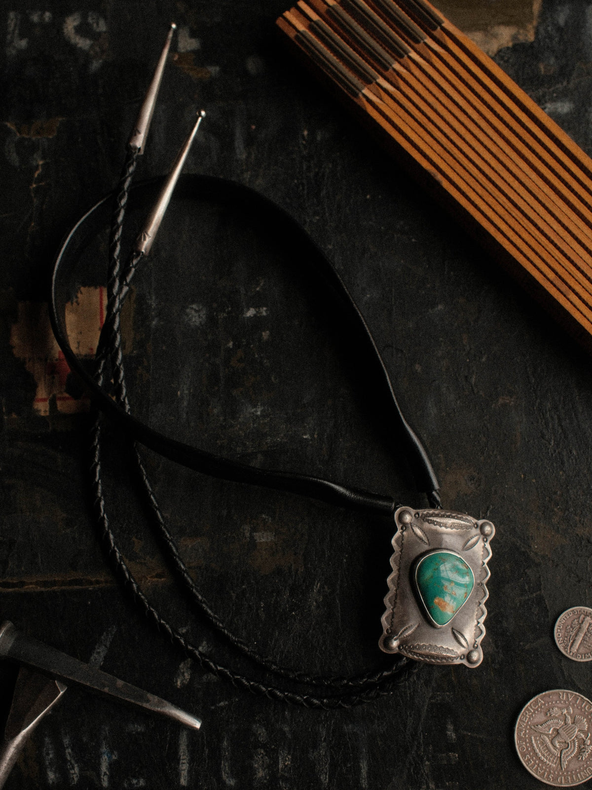 A Royston turquoise bolo, hand-stamped for dimension and set on braided leather with sterling end tips
