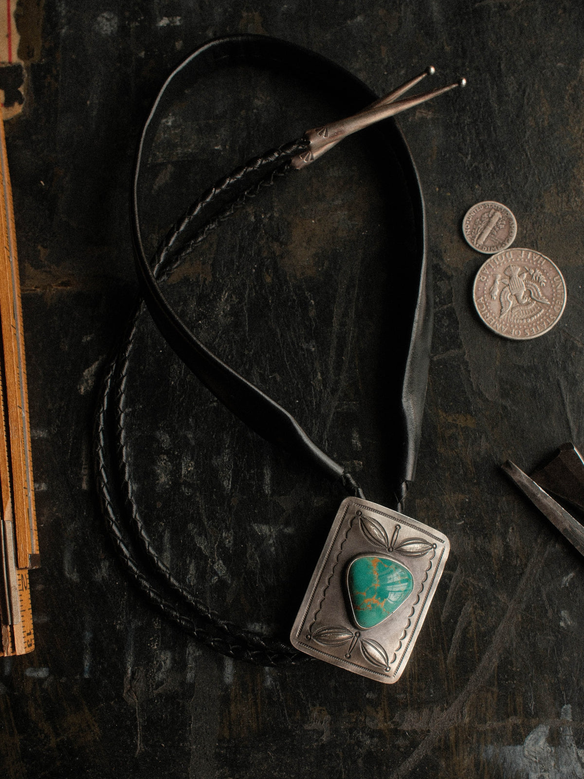 Hand-stamped with bump-outs and centered on Royston turquoise from Nevada, strung on braided leather with sterling tips