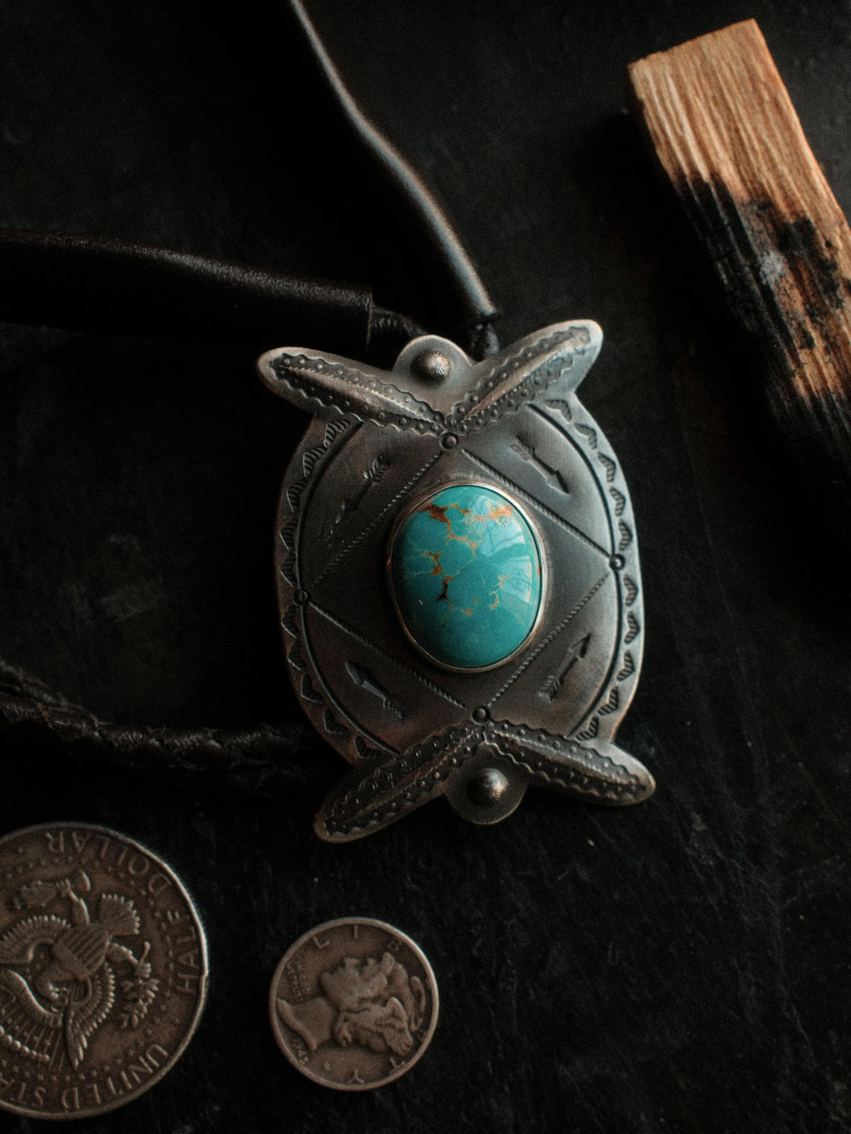 Royston turquoise from Nevada, hand-stamped with bump-outs for dimension, on a braided leather cord with sterling tips.
