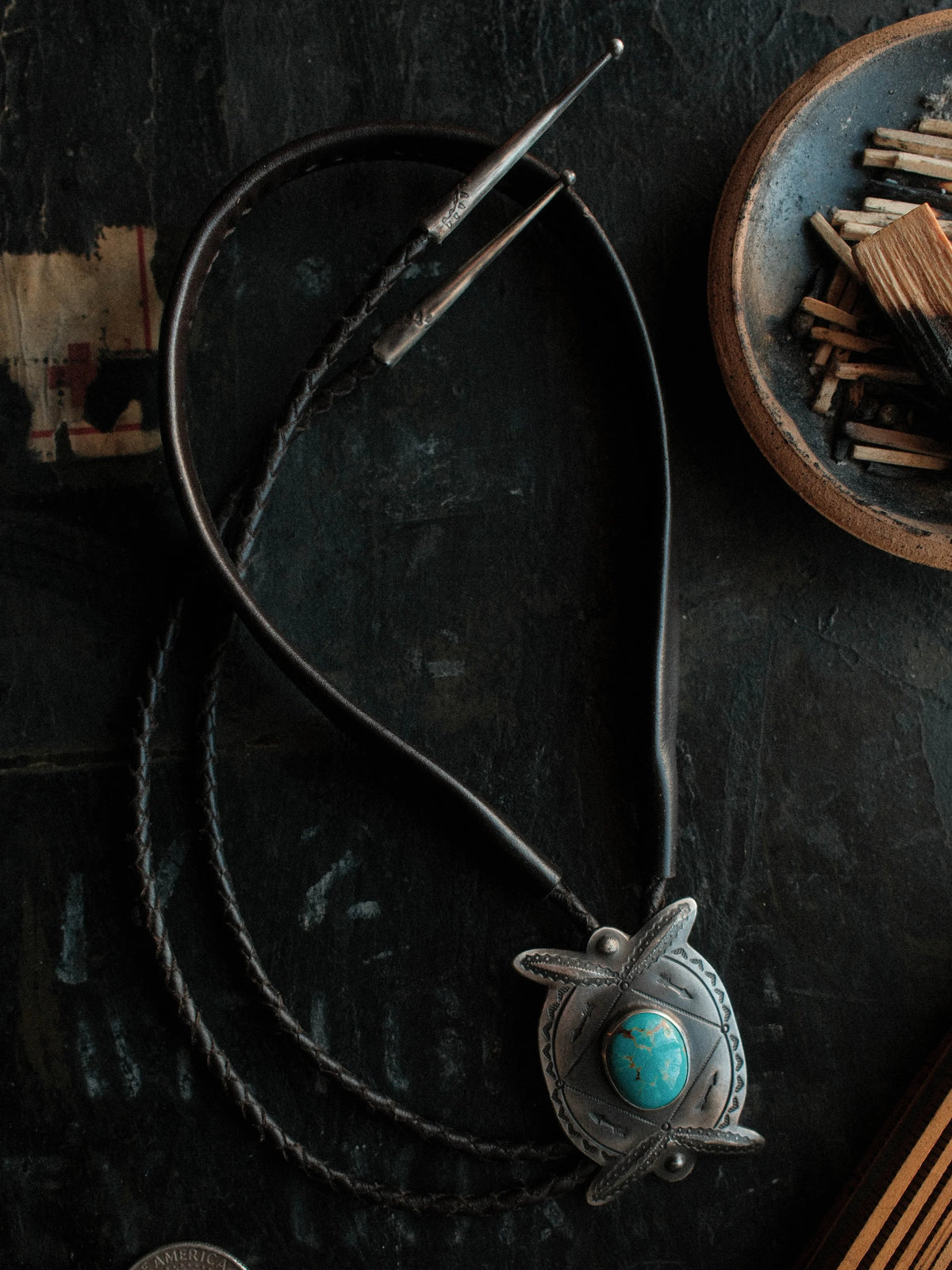 Royston turquoise from Nevada, hand-stamped with bump-outs for dimension, on a braided leather cord with sterling tips. — view 3